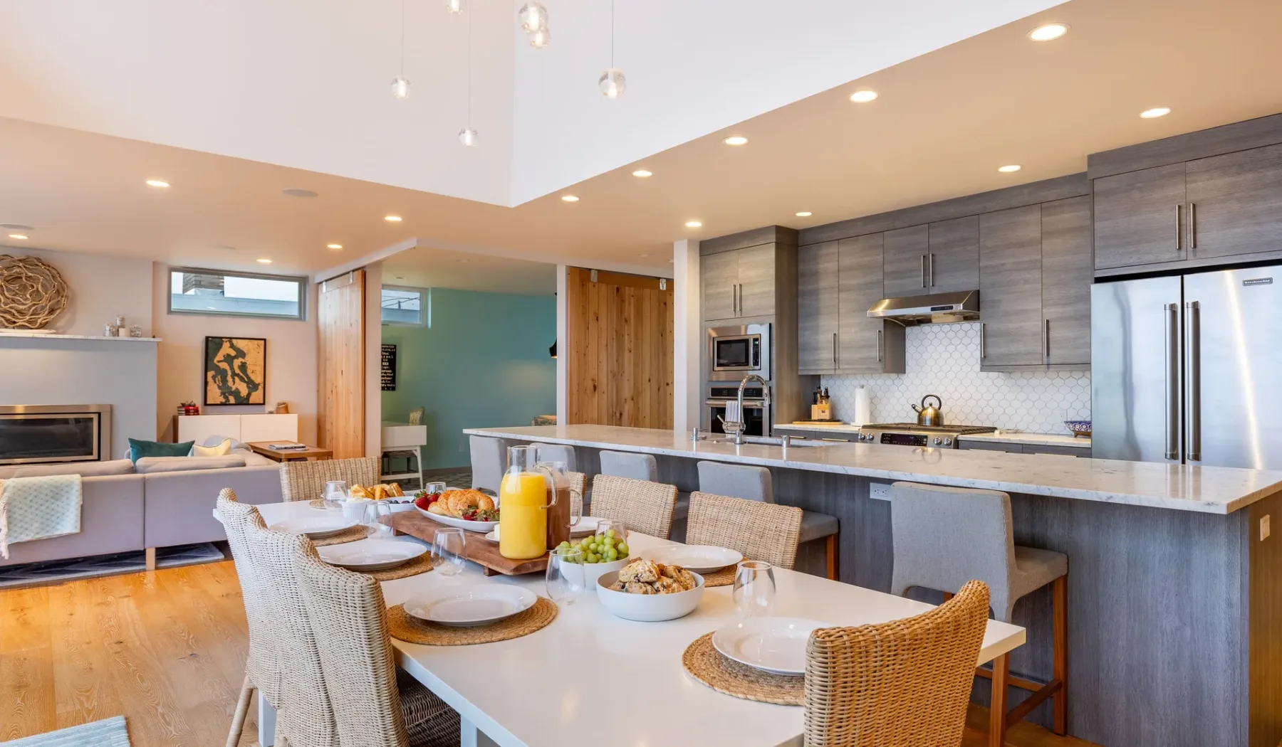 An open-plan dining area and kitchen with a table set for a meal.