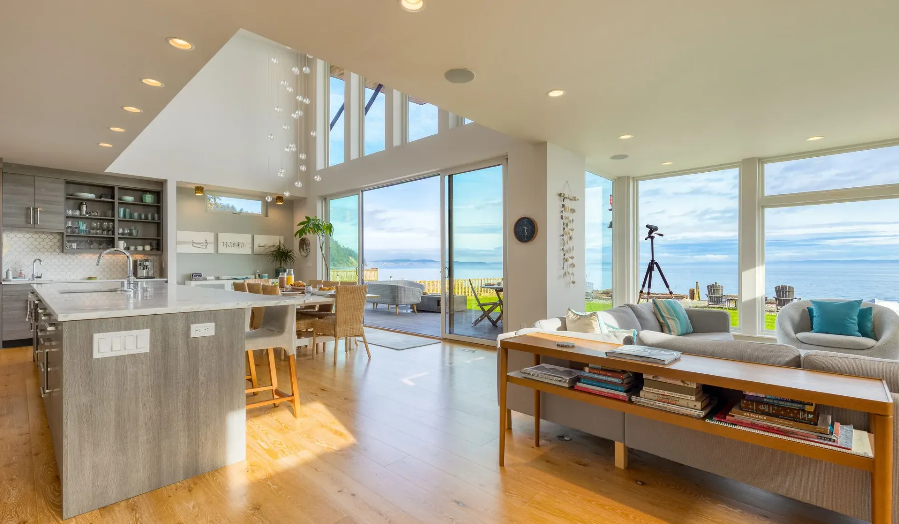 An open-plan living and dining area with a kitchen and large windows.