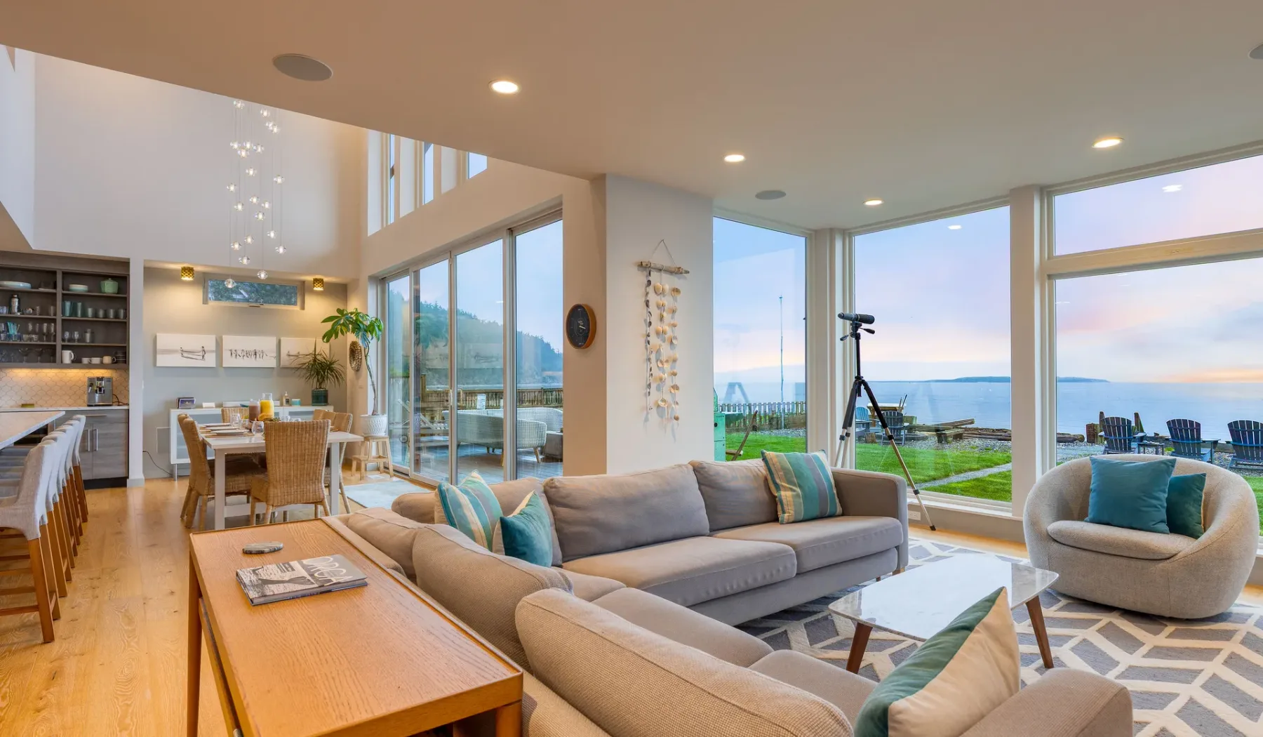 An open-plan living and dining area with seating beside large windows.