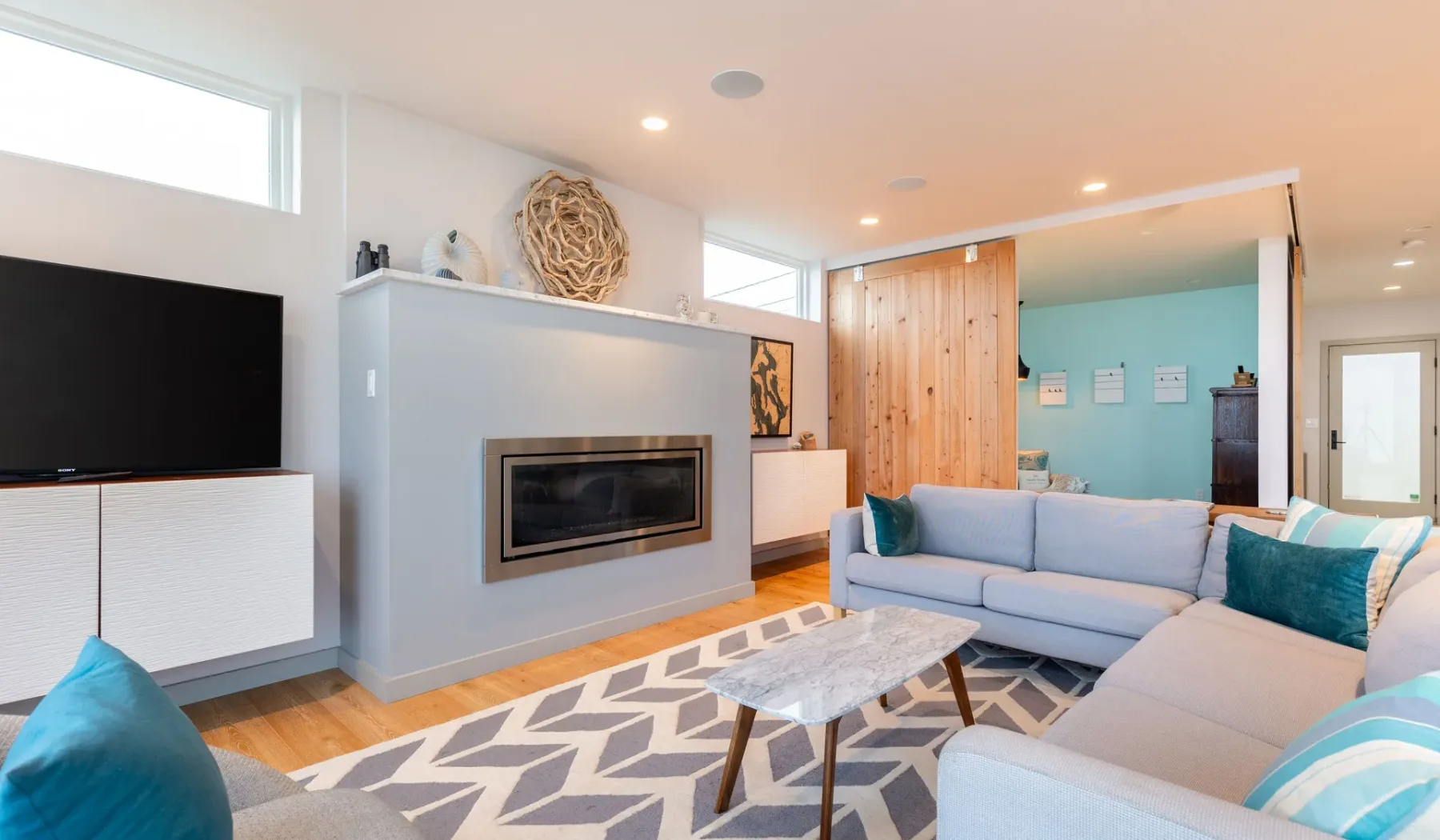 A bright living room with an L-shaped seating area and a fireplace.