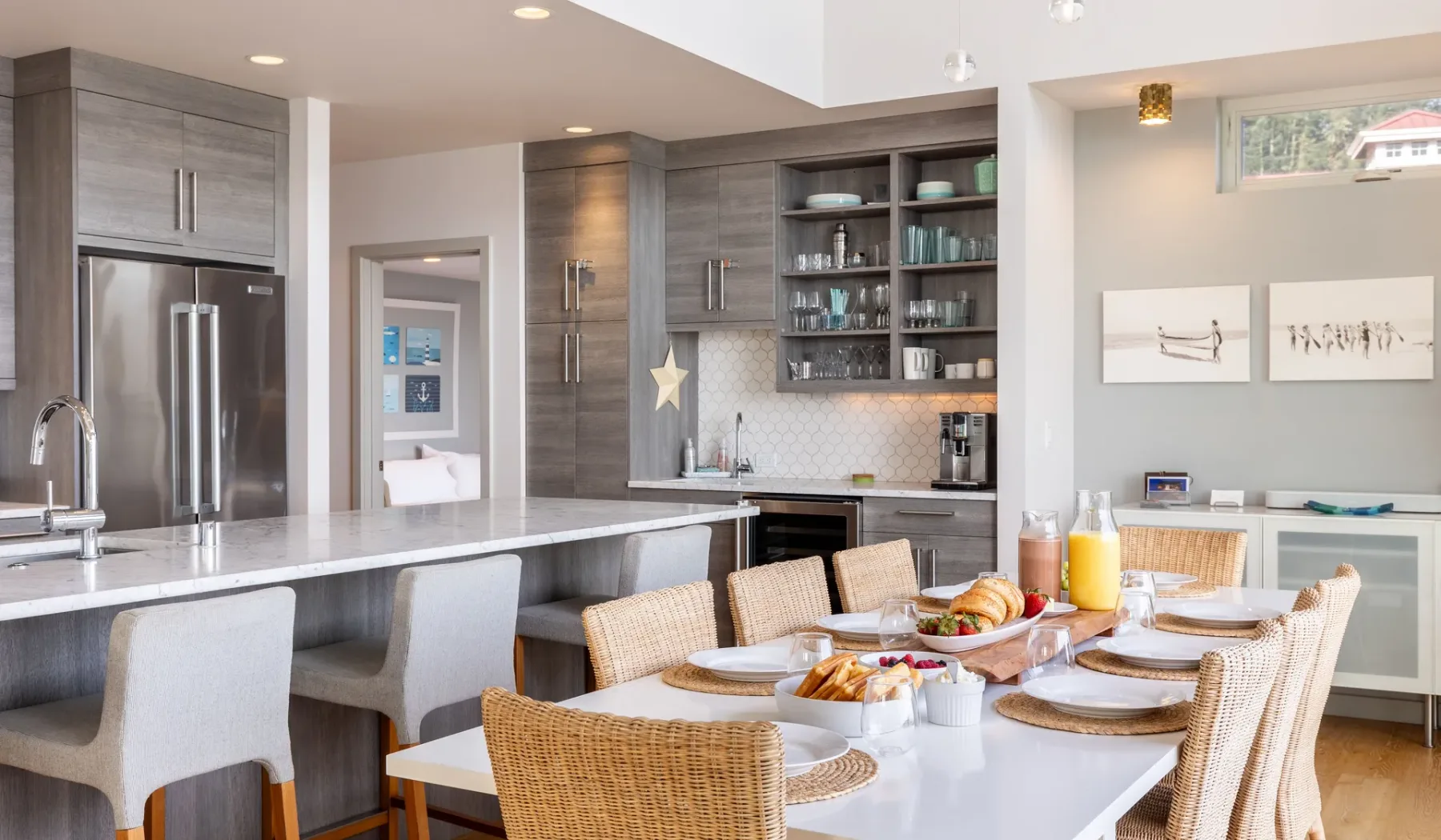 A modern kitchen and dining area with a long island and a set dining table.