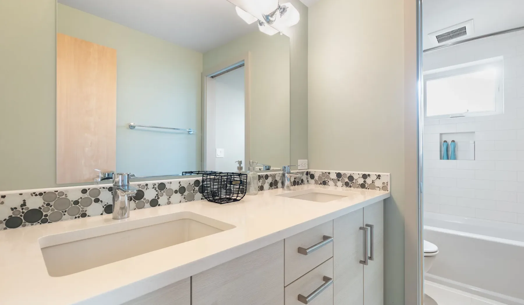 A bathroom vanity with a sink and a bathtub in the background.