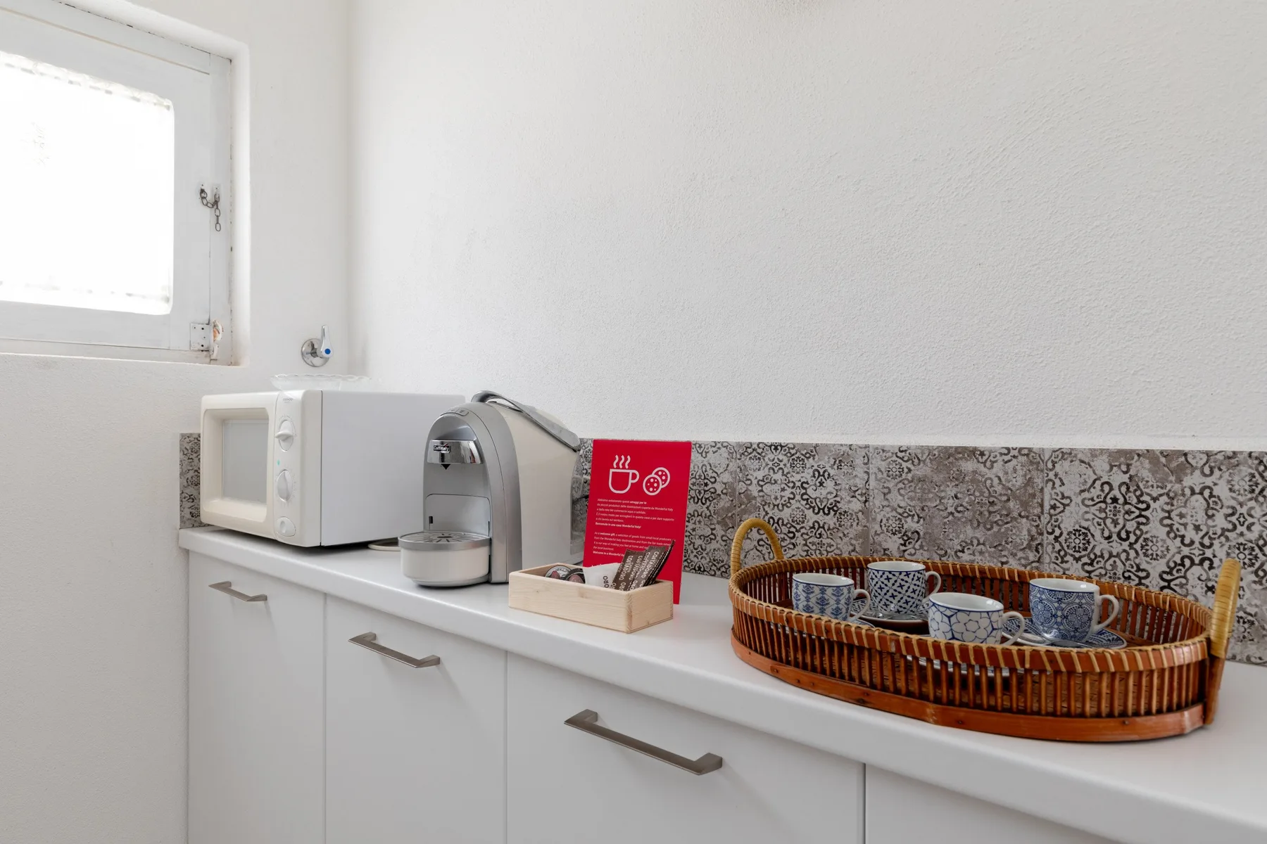 A bright kitchenette counter with a microwave and coffee maker.