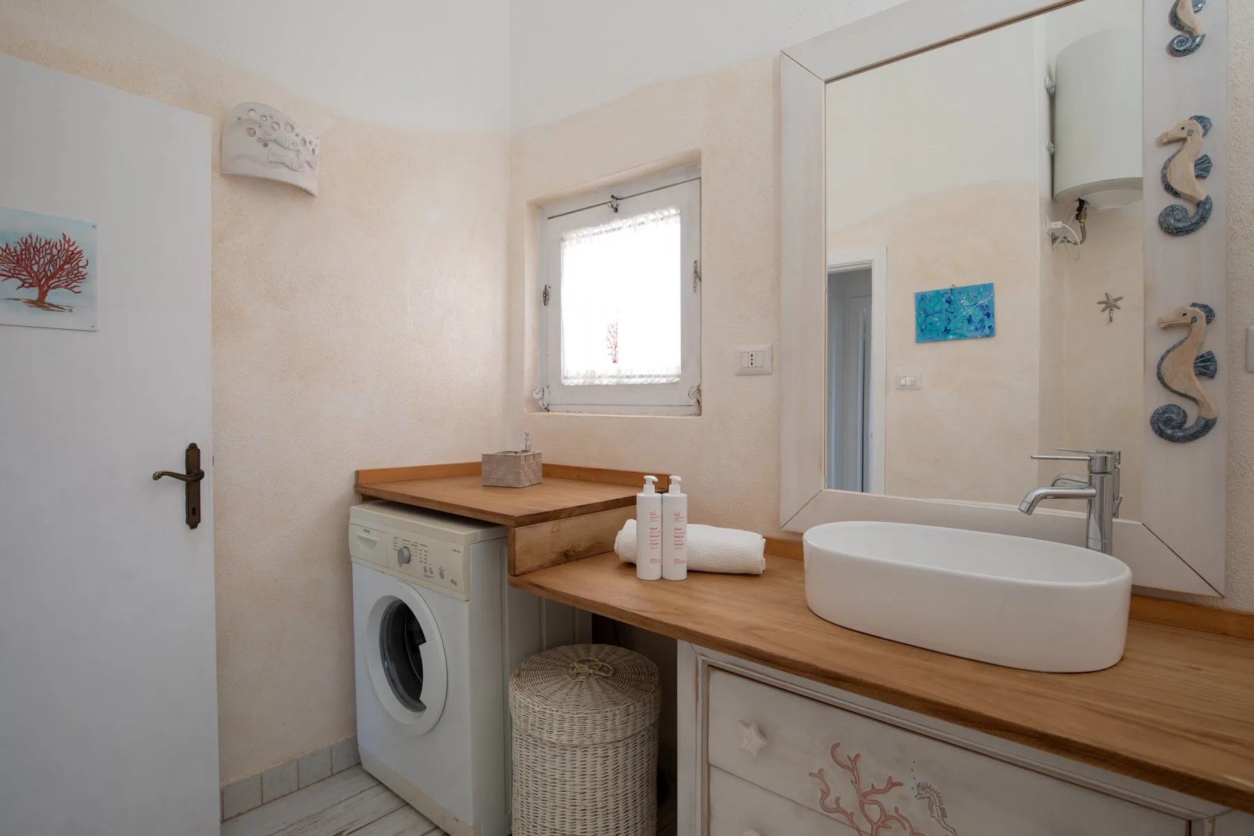 A bathroom vanity with a basin, mirror, and washing machine.