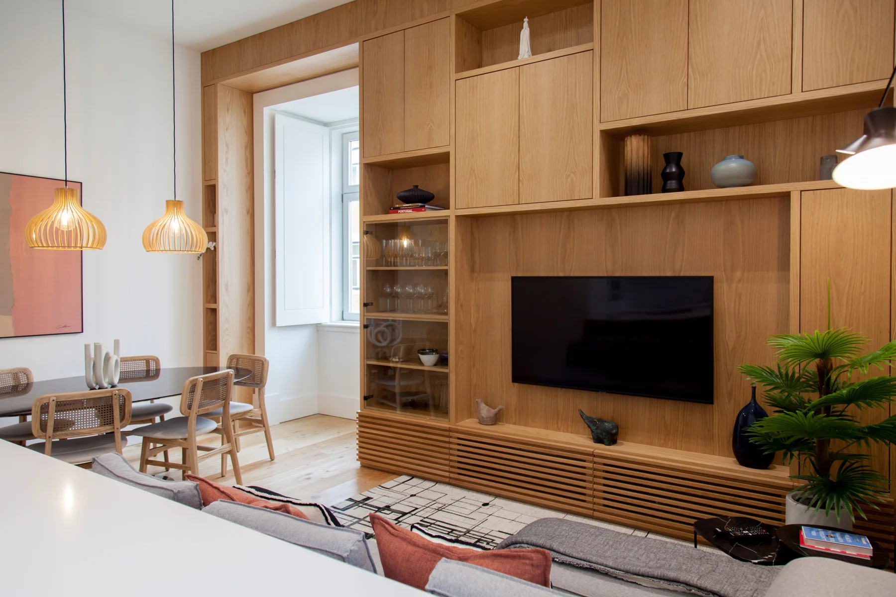 Living room with a wall-mounted television and built-in wooden cabinetry.