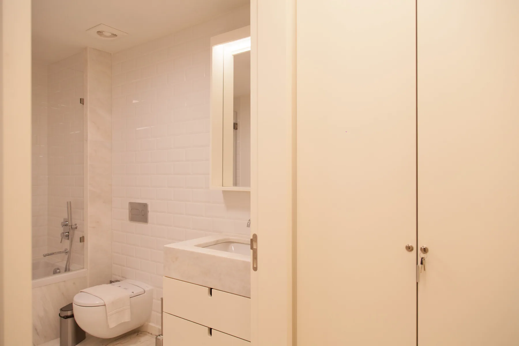 A bright bathroom with a shower, sink, and toilet.