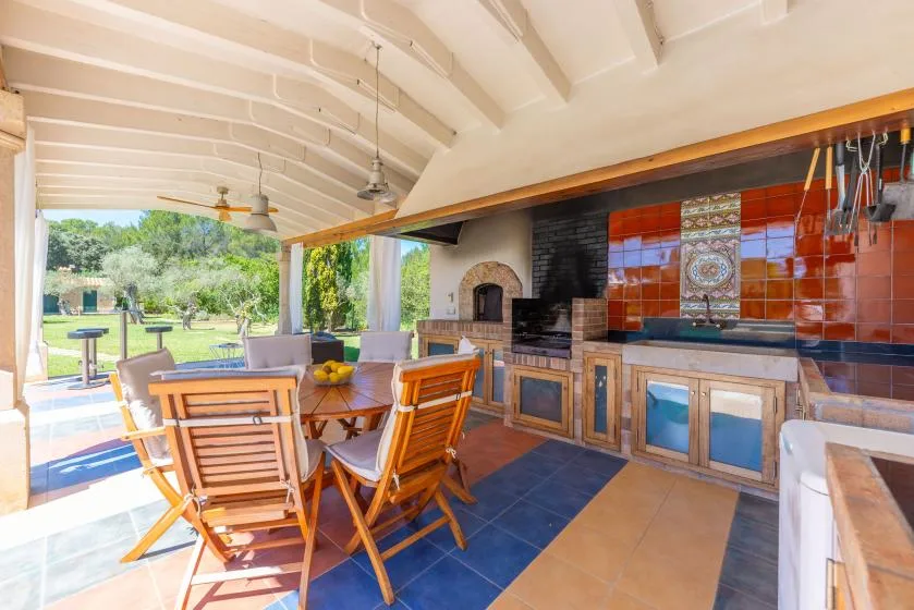 Una cocina y comedor al aire libre se abren a un jardín.