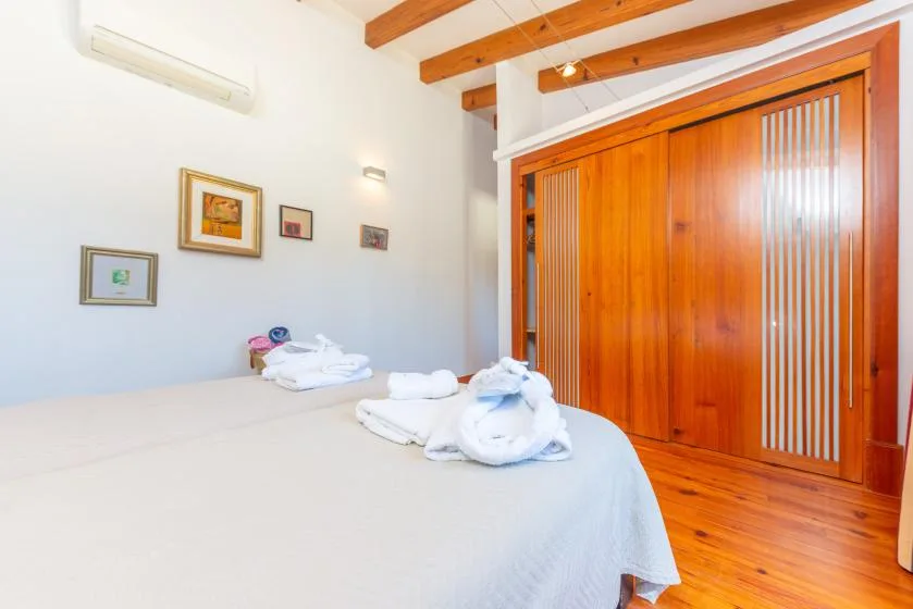 Un dormitorio con una cama bien tendida y puertas corredizas de madera.