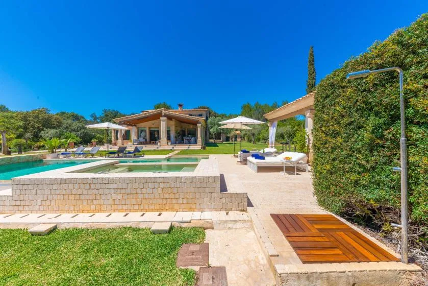 Una piscina al aire libre y un patio con asientos junto a una casa moderna.