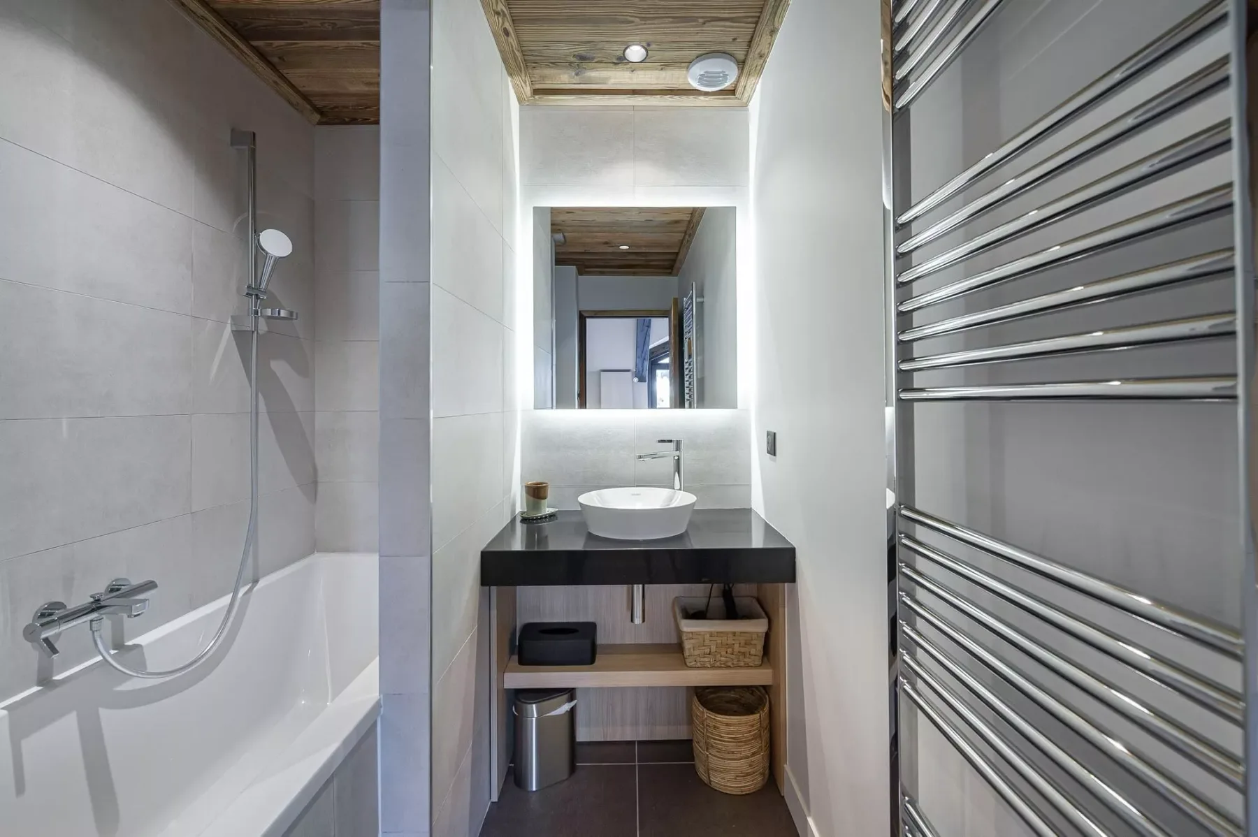 Un baño con bañera, ducha y lavabo bajo un espejo.