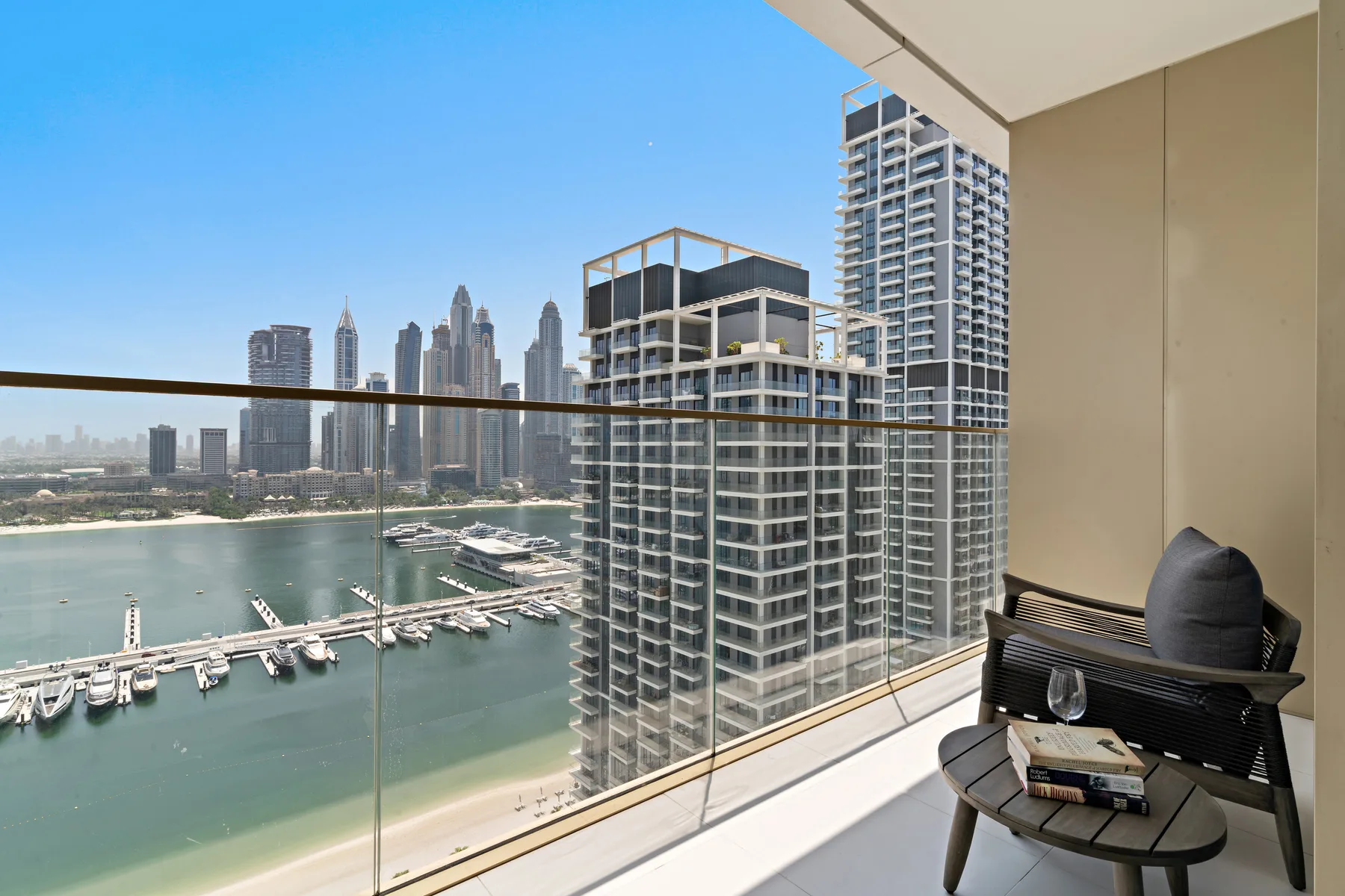 Un balcón ofrece vistas al paseo marítimo, la marina y el horizonte urbano.