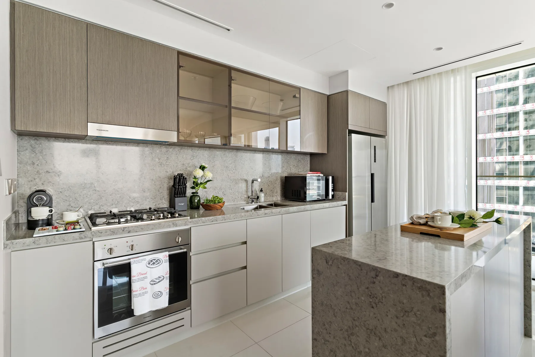 Una cocina moderna con gabinetes claros, una estufa y una isla grande.