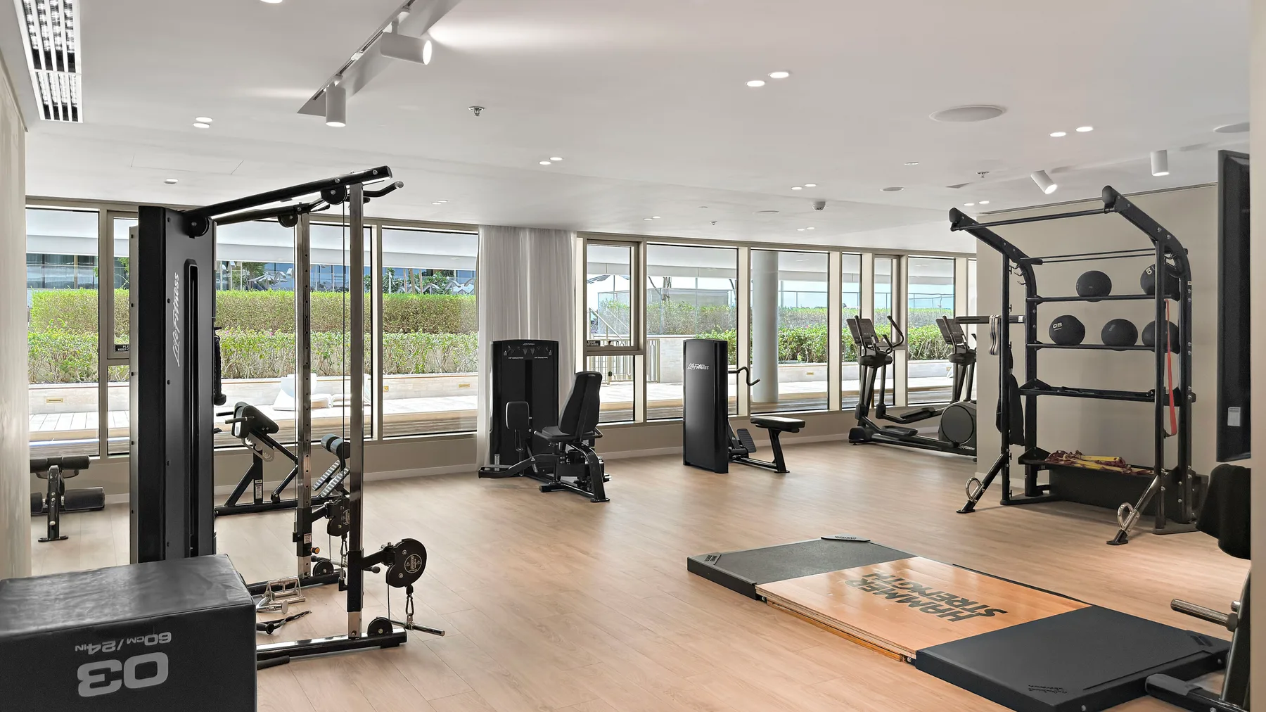 Un gimnasio amplio con máquinas de ejercicio y una zona de entrenamiento con pesas.