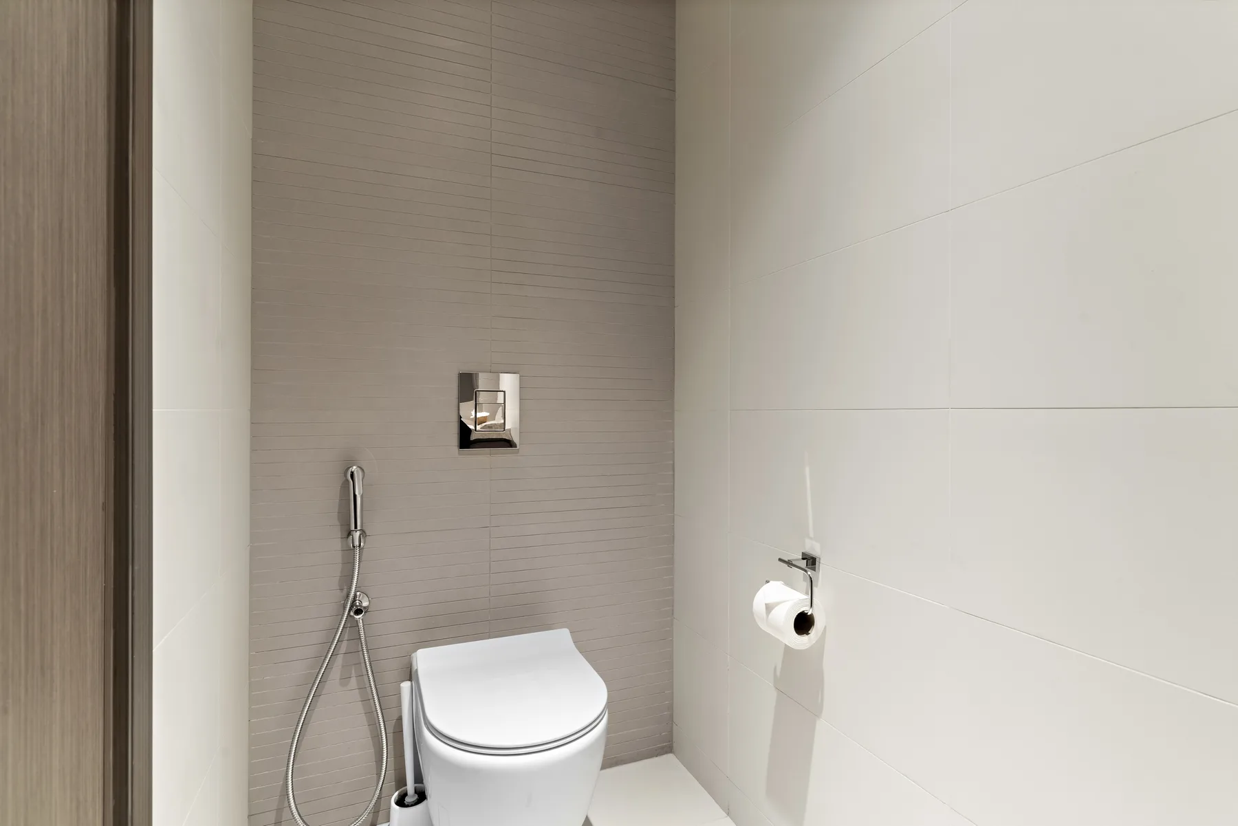 Un baño moderno con inodoro y ducha de mano.