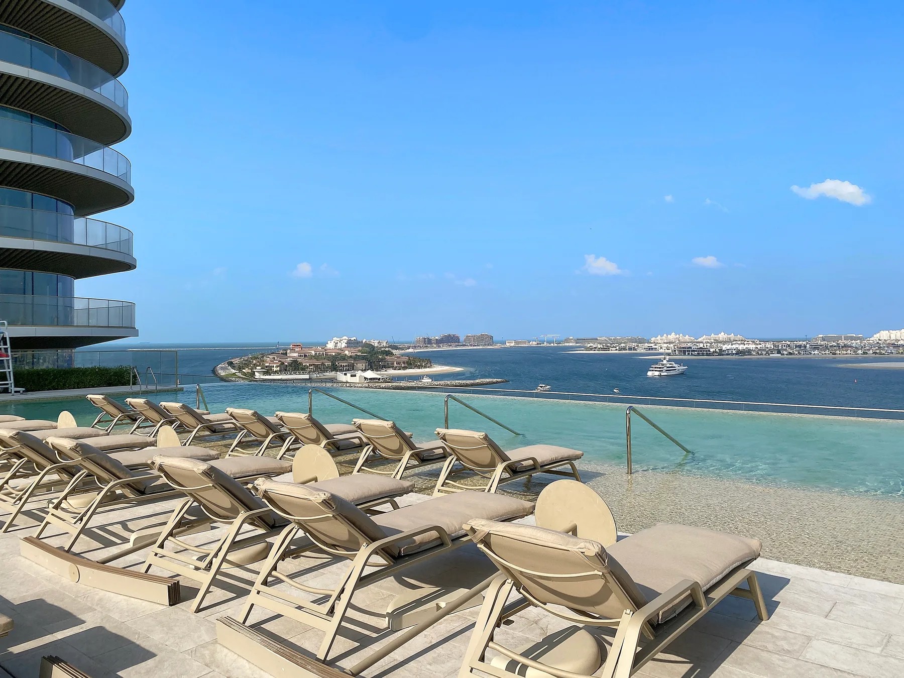 Una terraza junto al mar con tumbonas frente al agua.