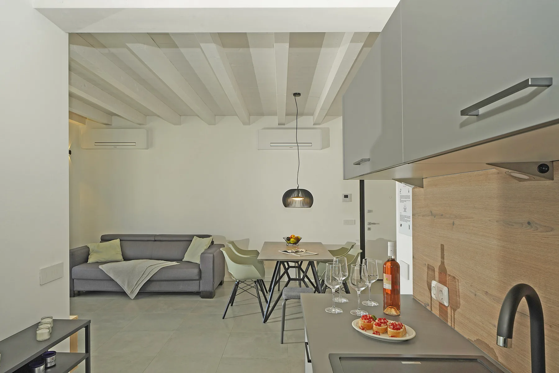 An open-plan kitchen and dining area with a sofa and table.