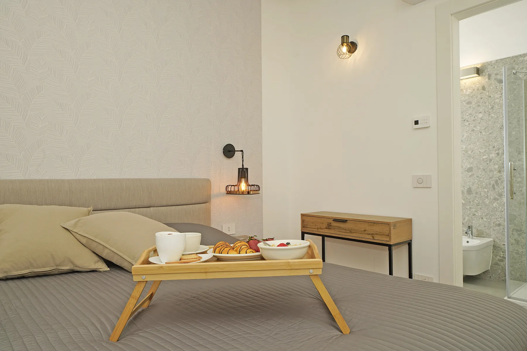 A bedroom with a bed and a breakfast tray set across it.