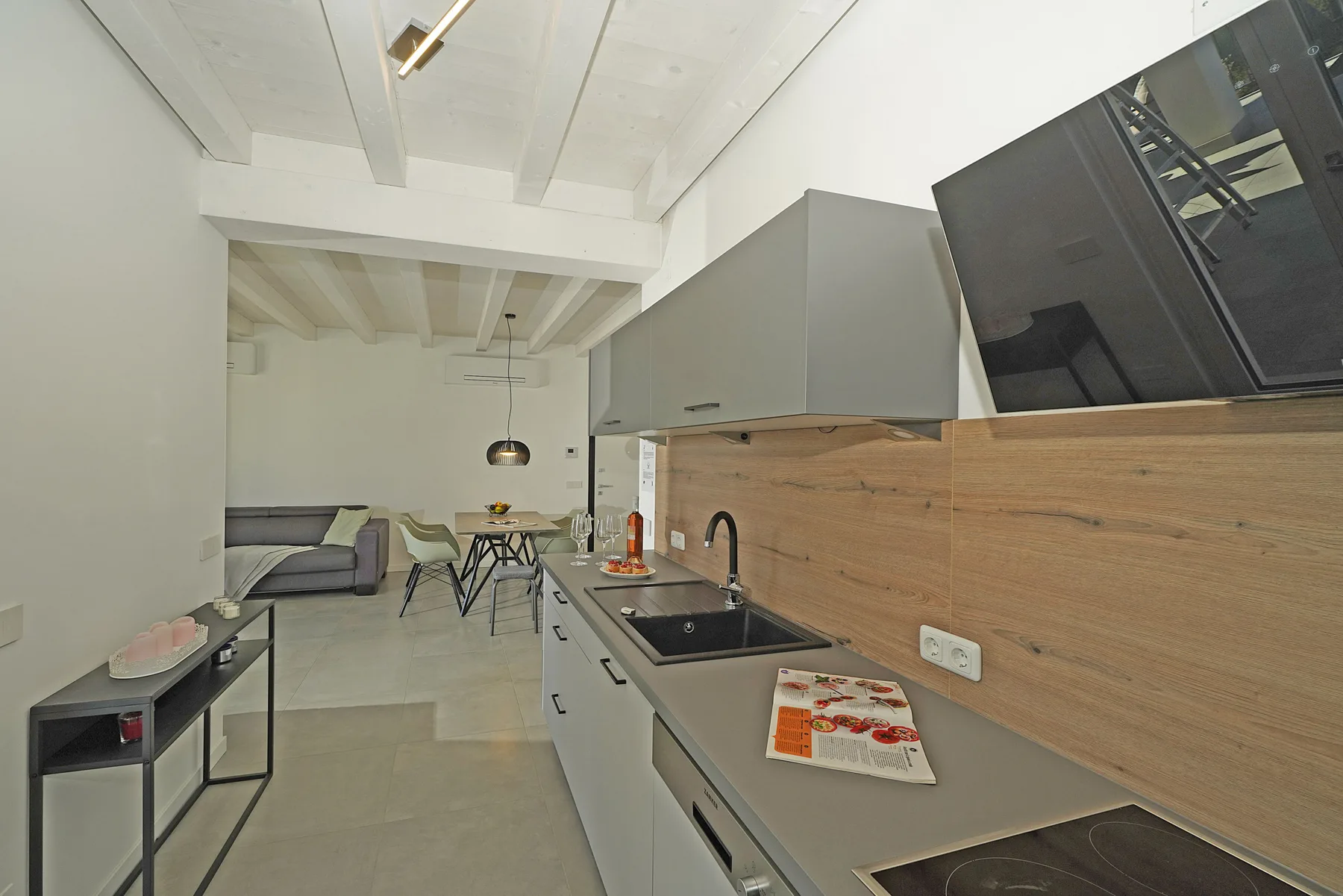 An open-plan kitchen and dining area with a living space beyond.
