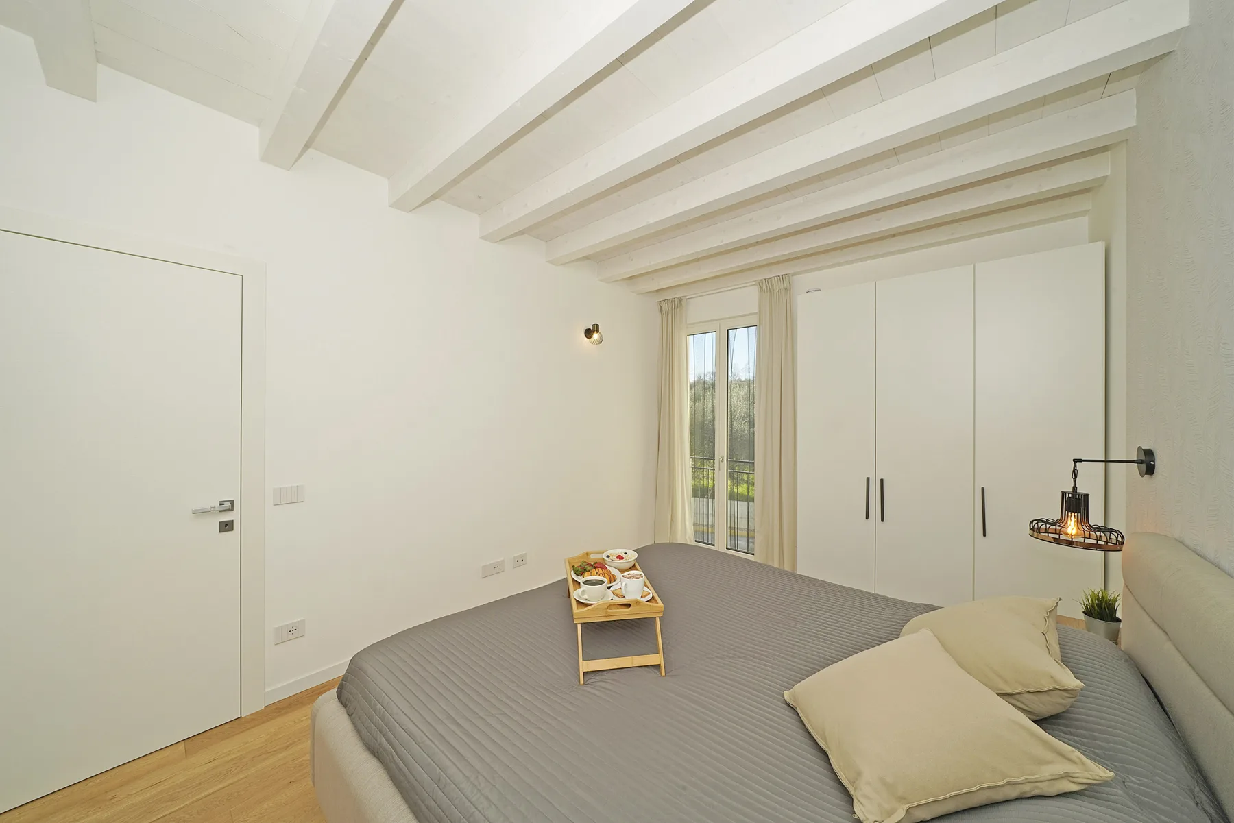 A bright bedroom with a bed and built-in wardrobes.