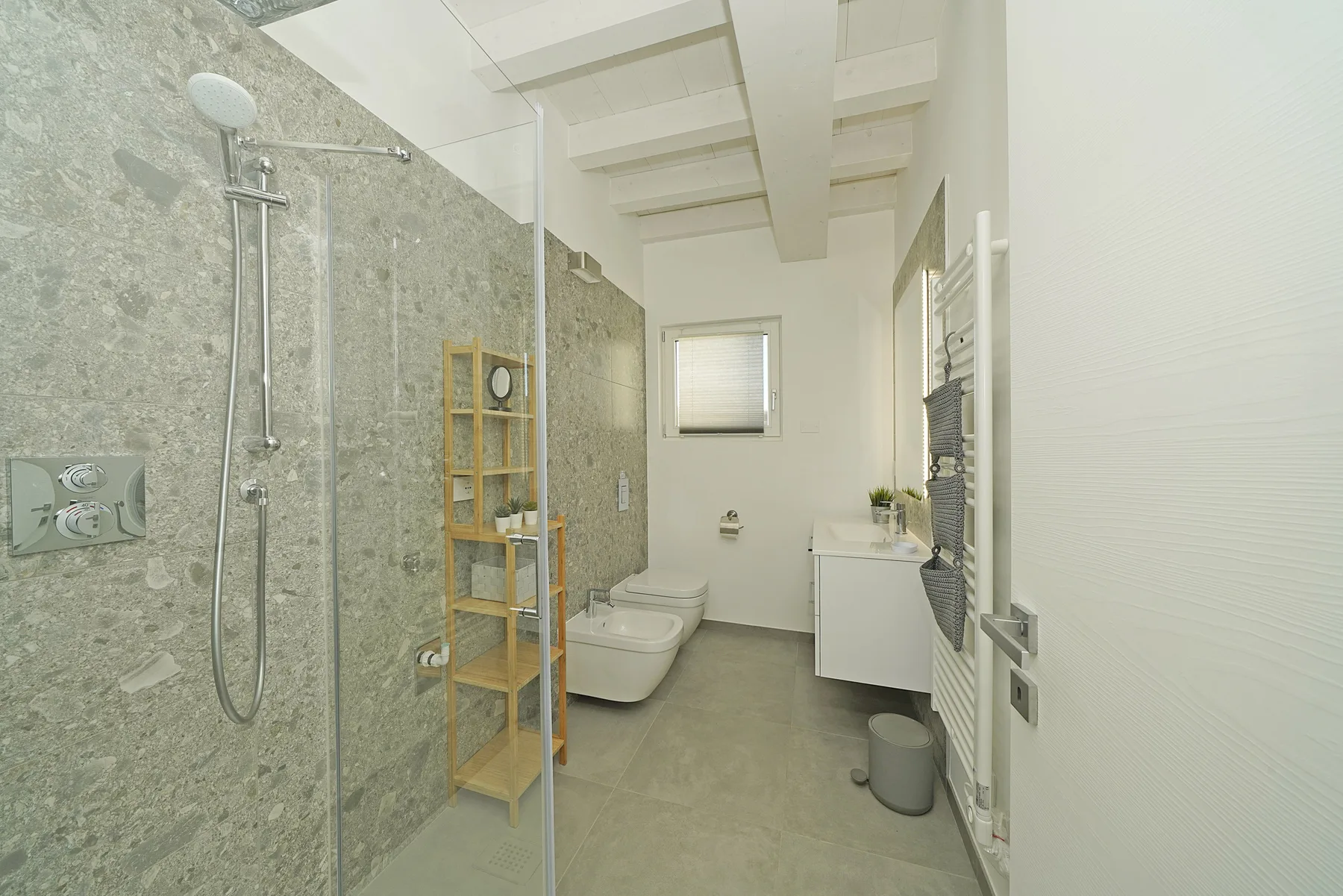 A bright bathroom with a walk-in shower, toilet, and vanity.