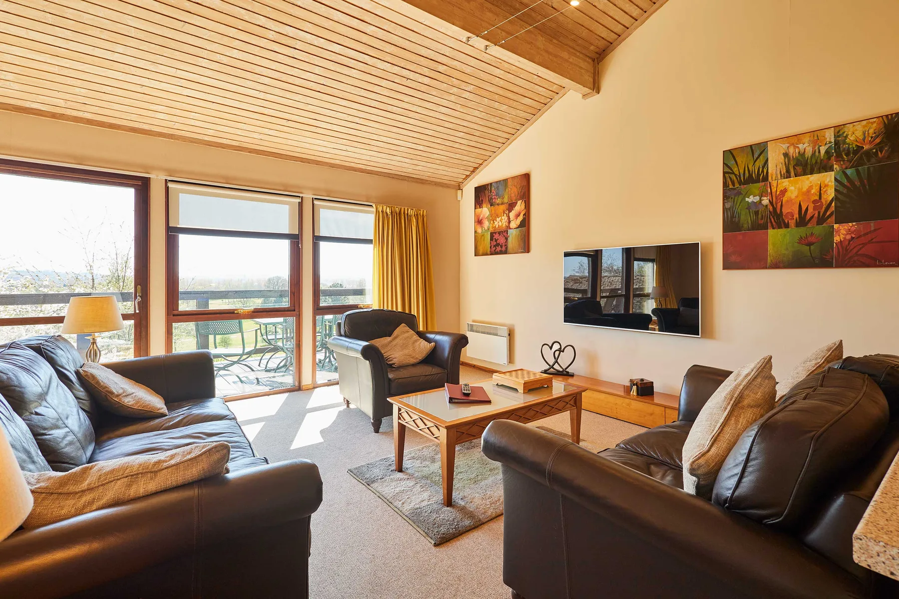 A living room with seating arranged around a coffee table and television.