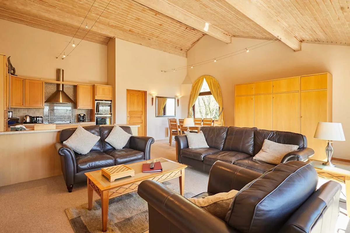 A living room with dark leather seating and a wooden coffee table.