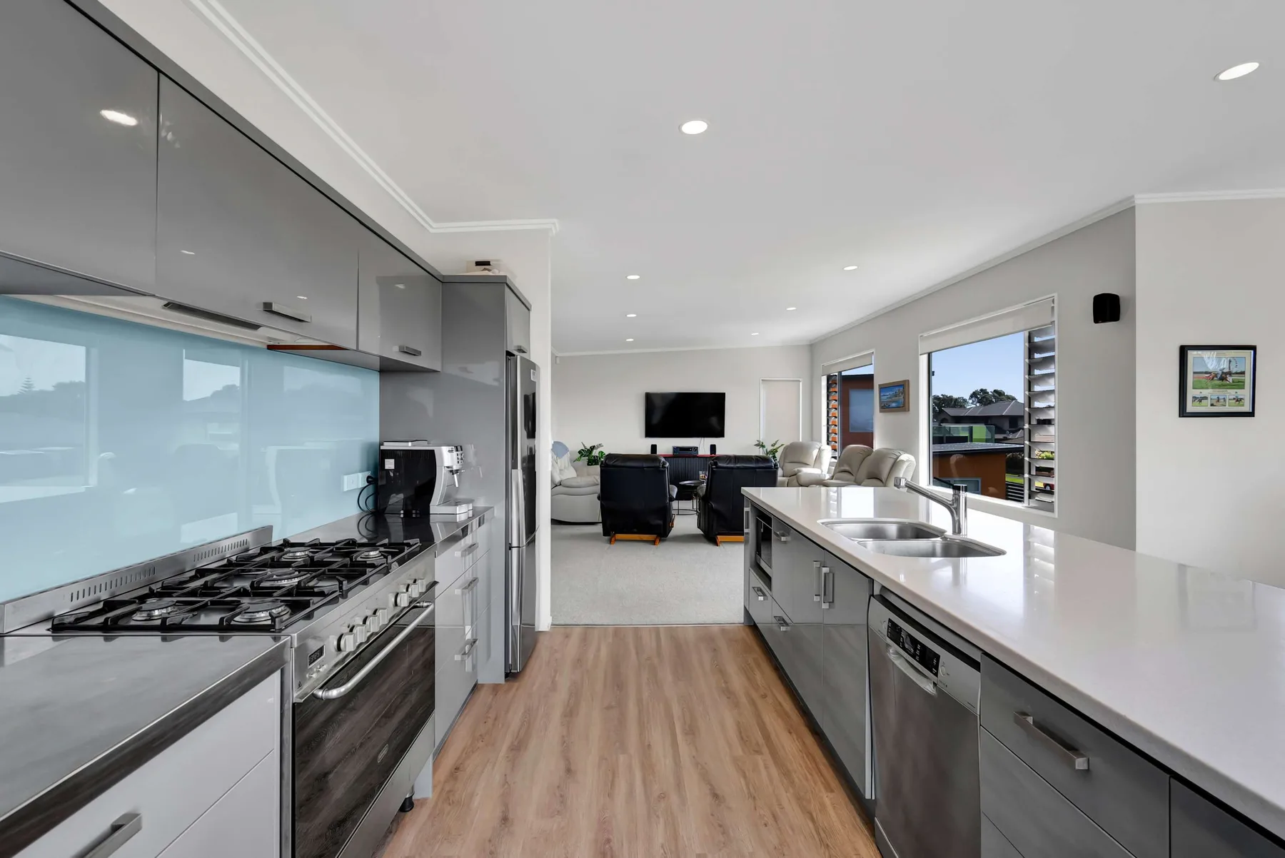 Una cocina moderna se abre a una sala de estar con televisor.