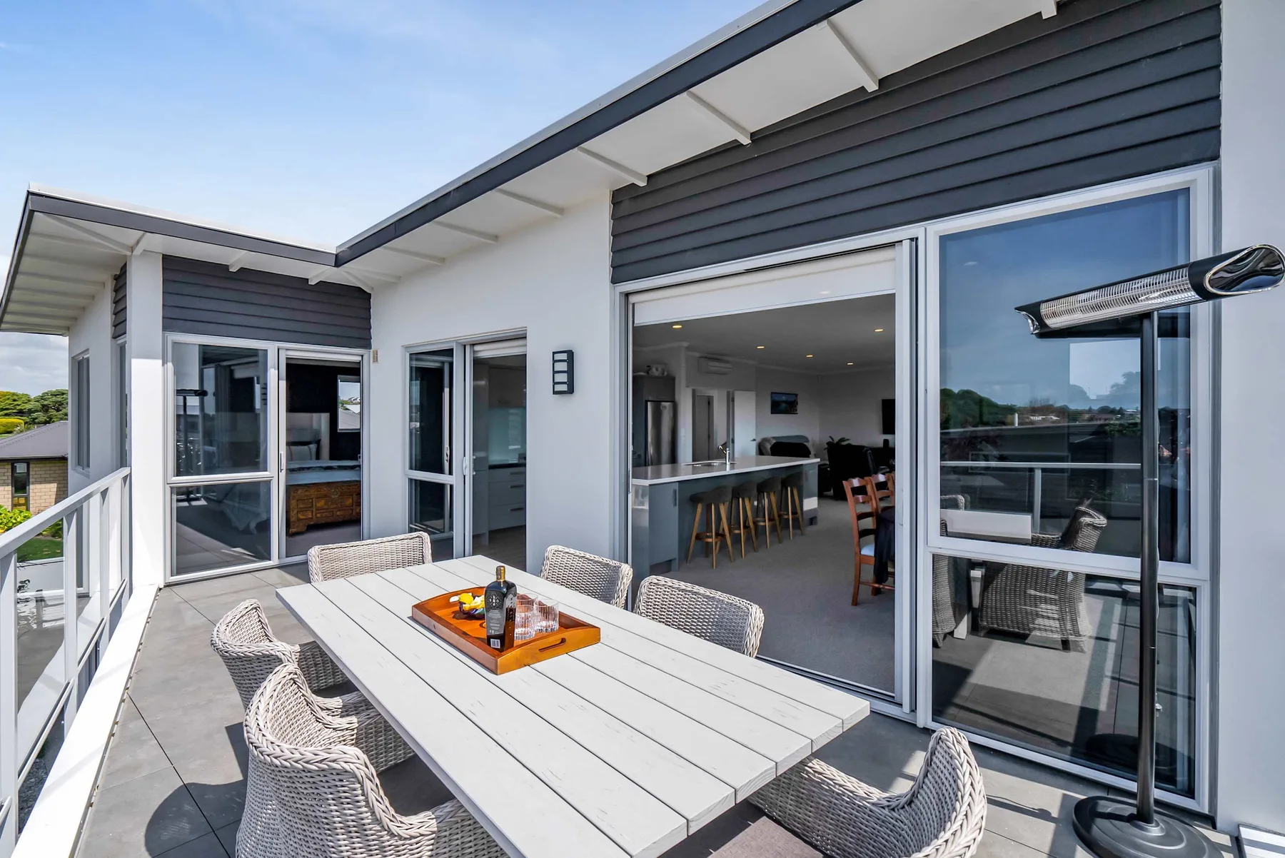 Una terraza en la azotea con una mesa de comedor junto a una cocina luminosa.