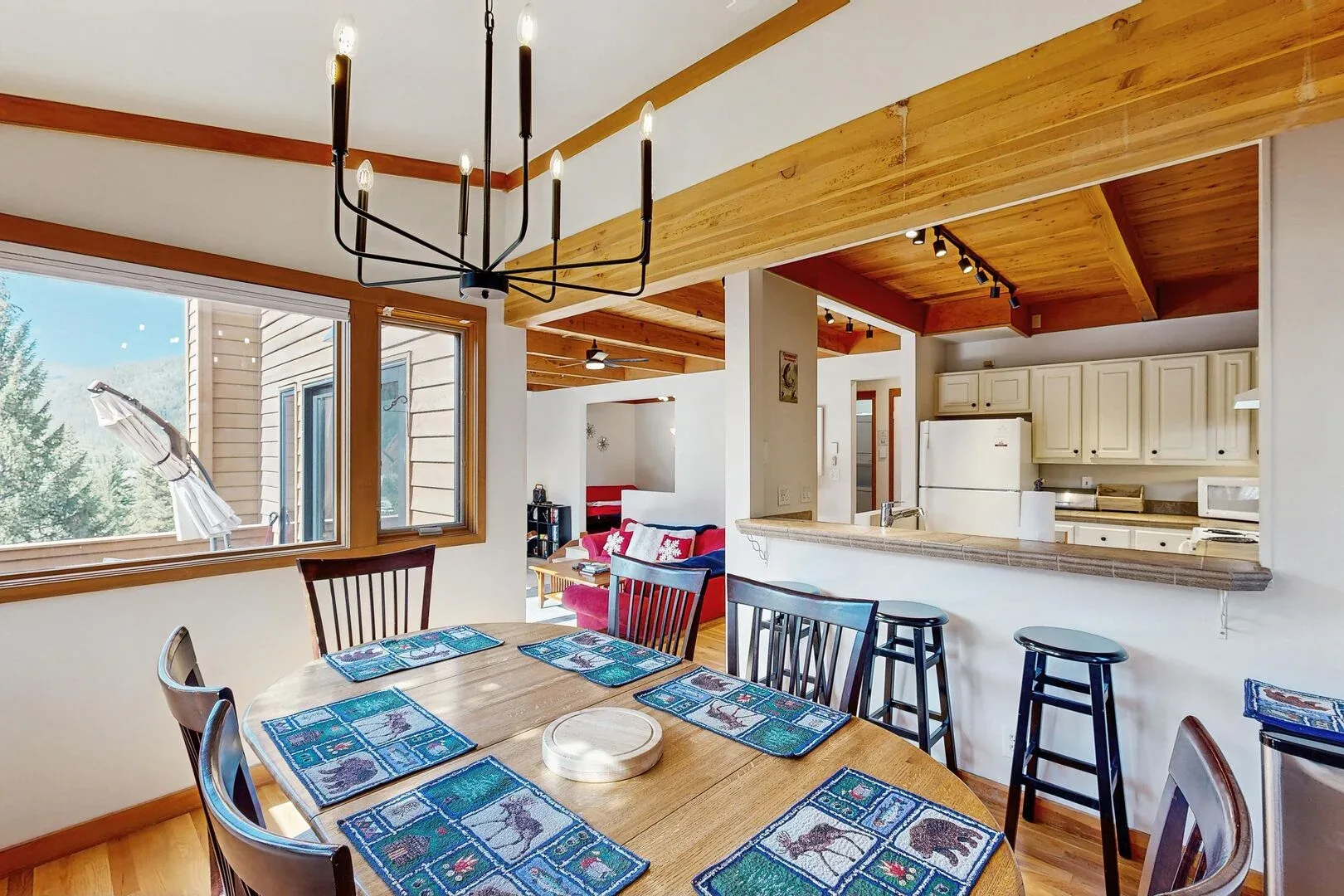An open dining and kitchen area with a wooden table and counter seating.