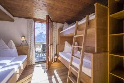 Habitación de tres camas con balcón y baño