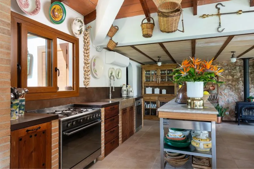 A rustic kitchen with wooden cabinets, a cooking range, and a central island.