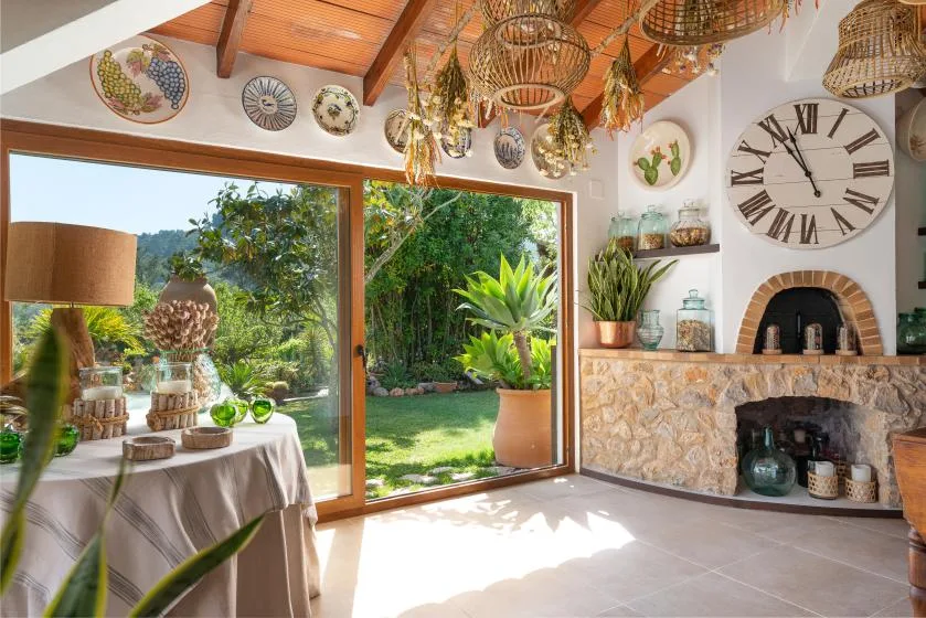A bright living area opens onto a garden through broad glass doors.