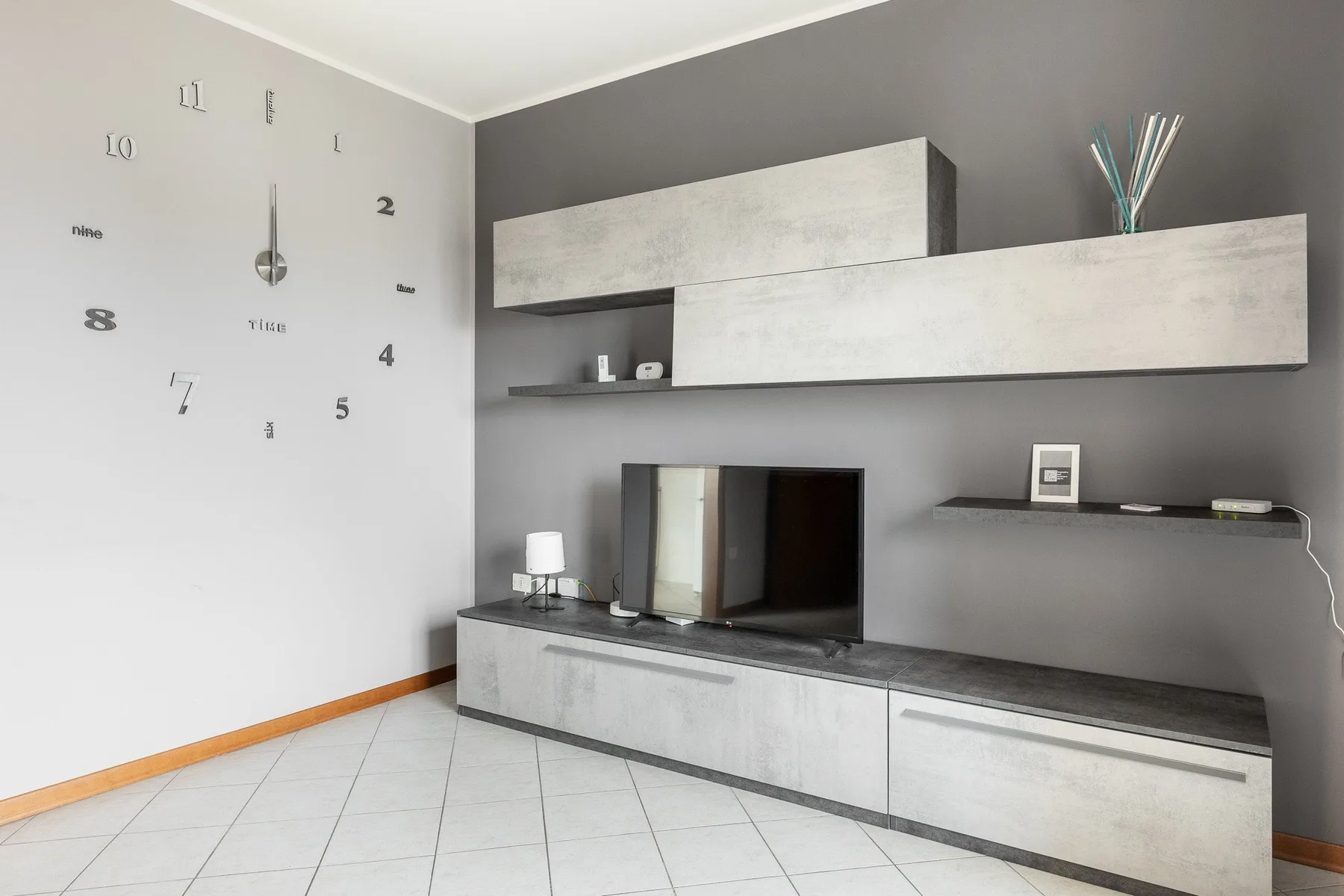 Una sala de estar moderna con almacenamiento en la pared y un televisor sobre un mueble bajo.
