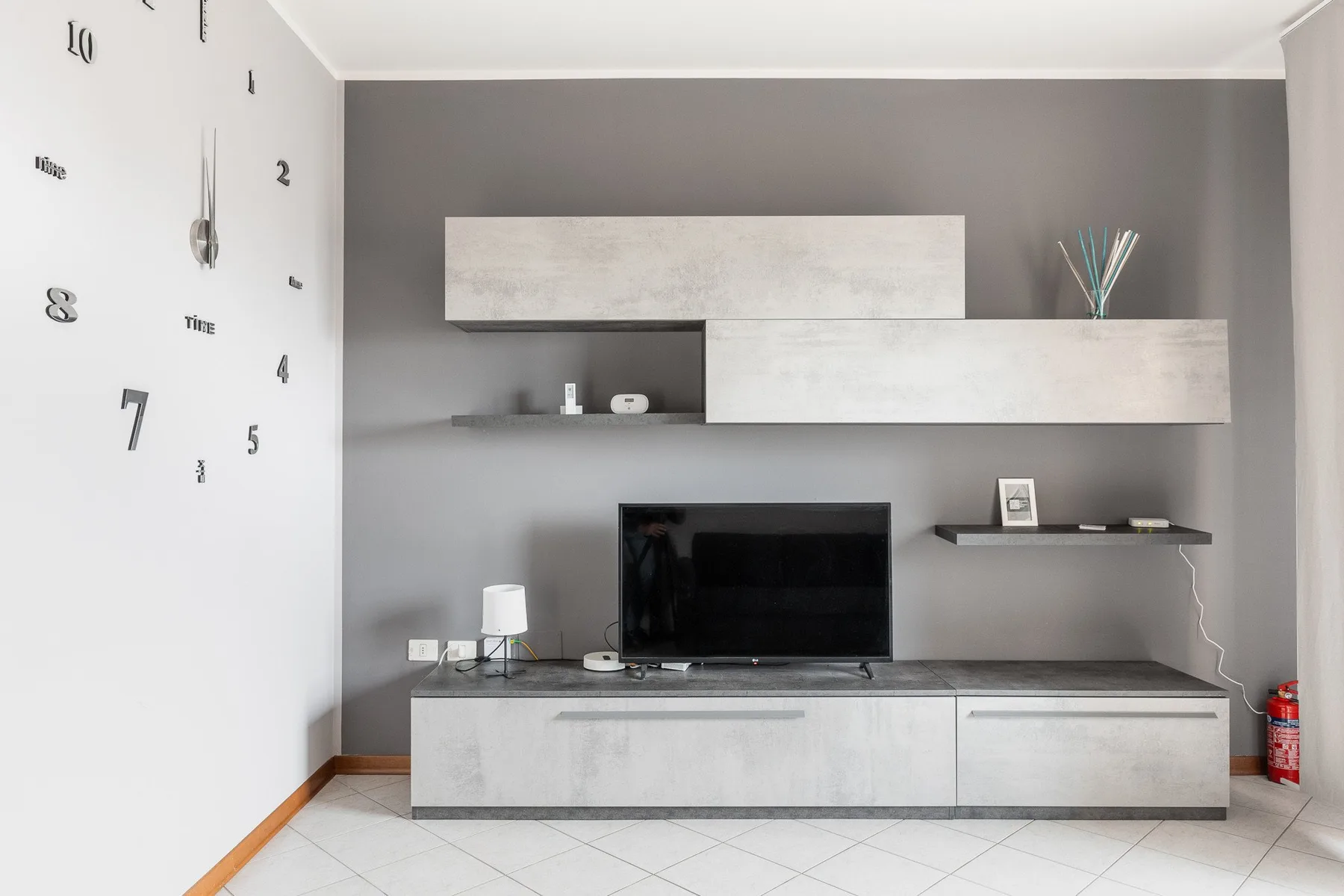 Una sala moderna con un televisor sobre un mueble bajo.