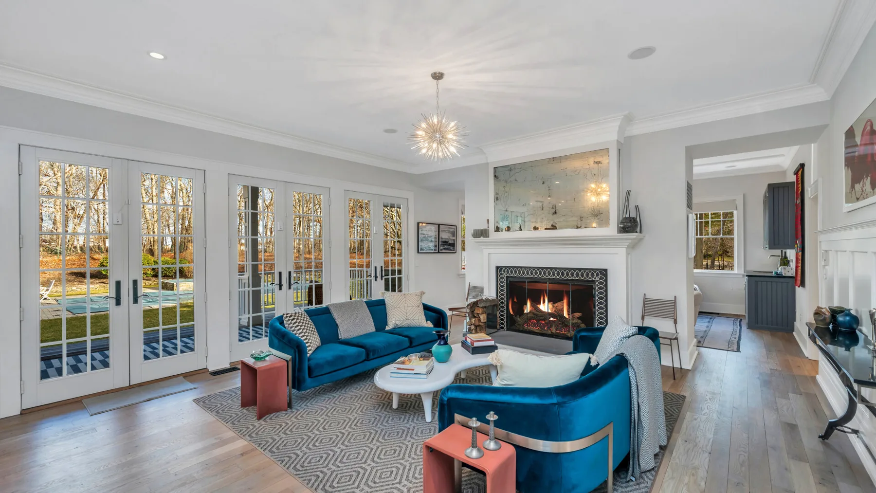 Una sala luminosa con asientos azules dispuestos alrededor de una chimenea.