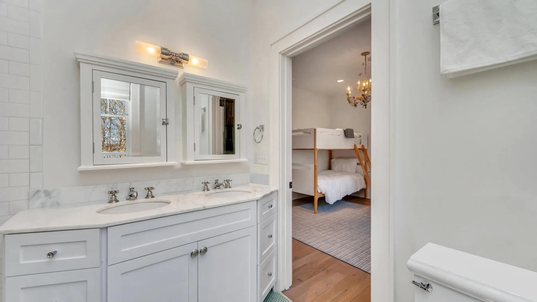 Un tocador de baño con espejo da a un dormitorio.