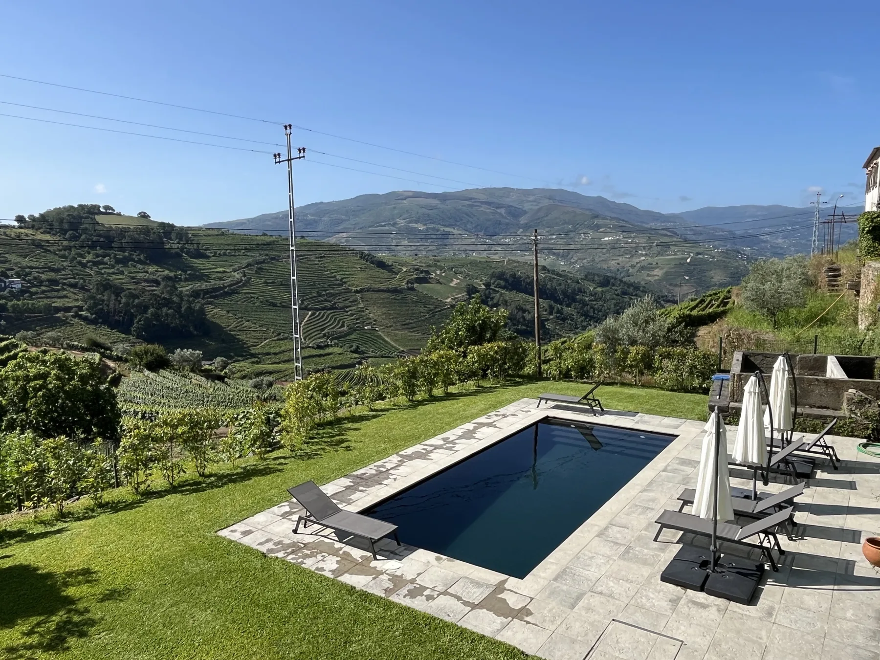 Una piscina al aire libre da a colinas en terrazas y un valle verde.