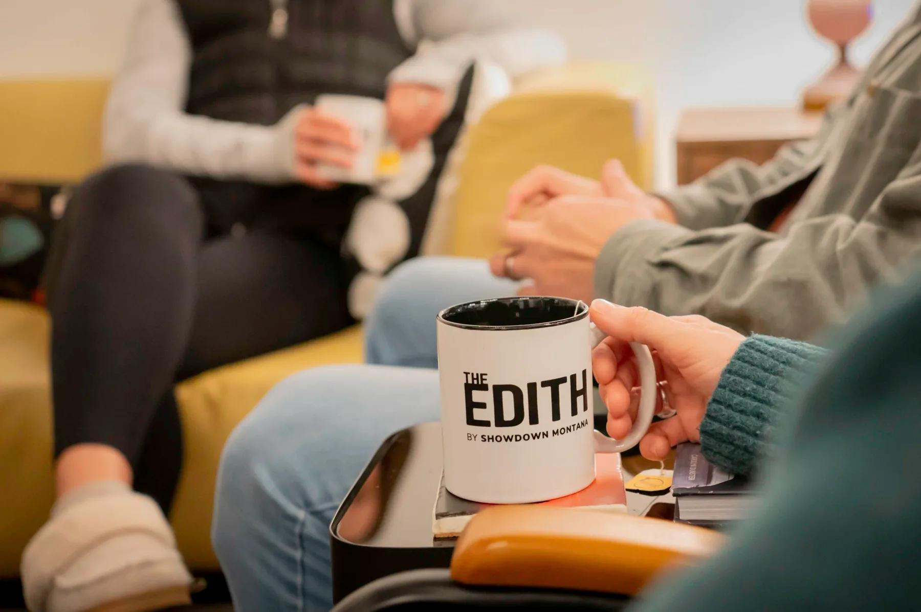 Edith coffee cup in a guest’s hand