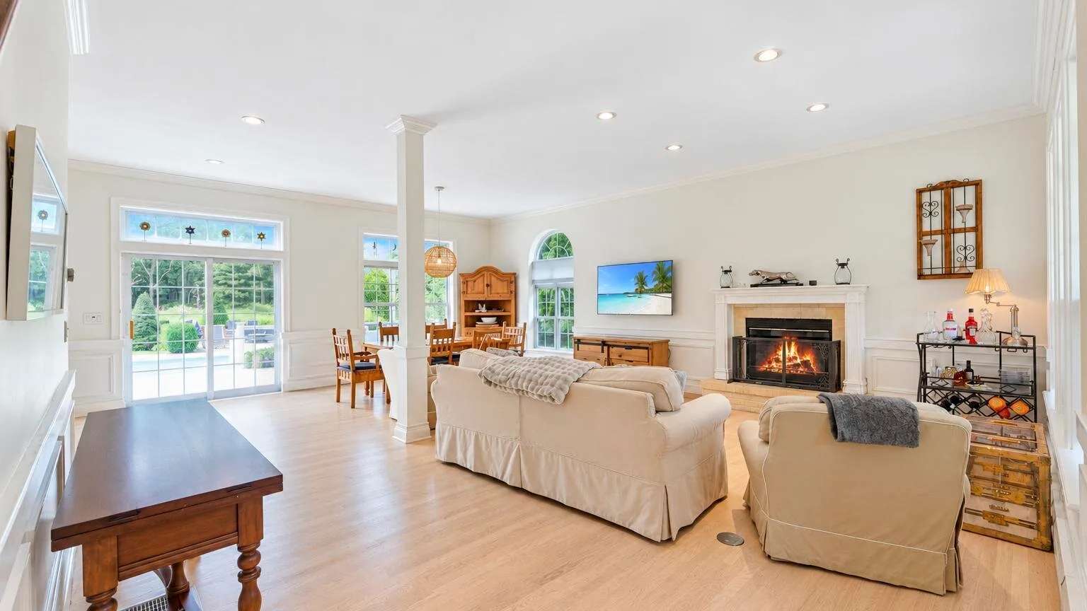 Una sala luminosa con sofás frente a una chimenea y un televisor.