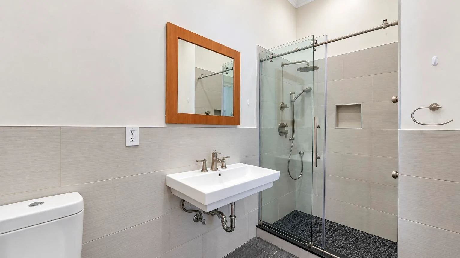 Un baño alicatado con lavabo, inodoro y ducha de vidrio.
