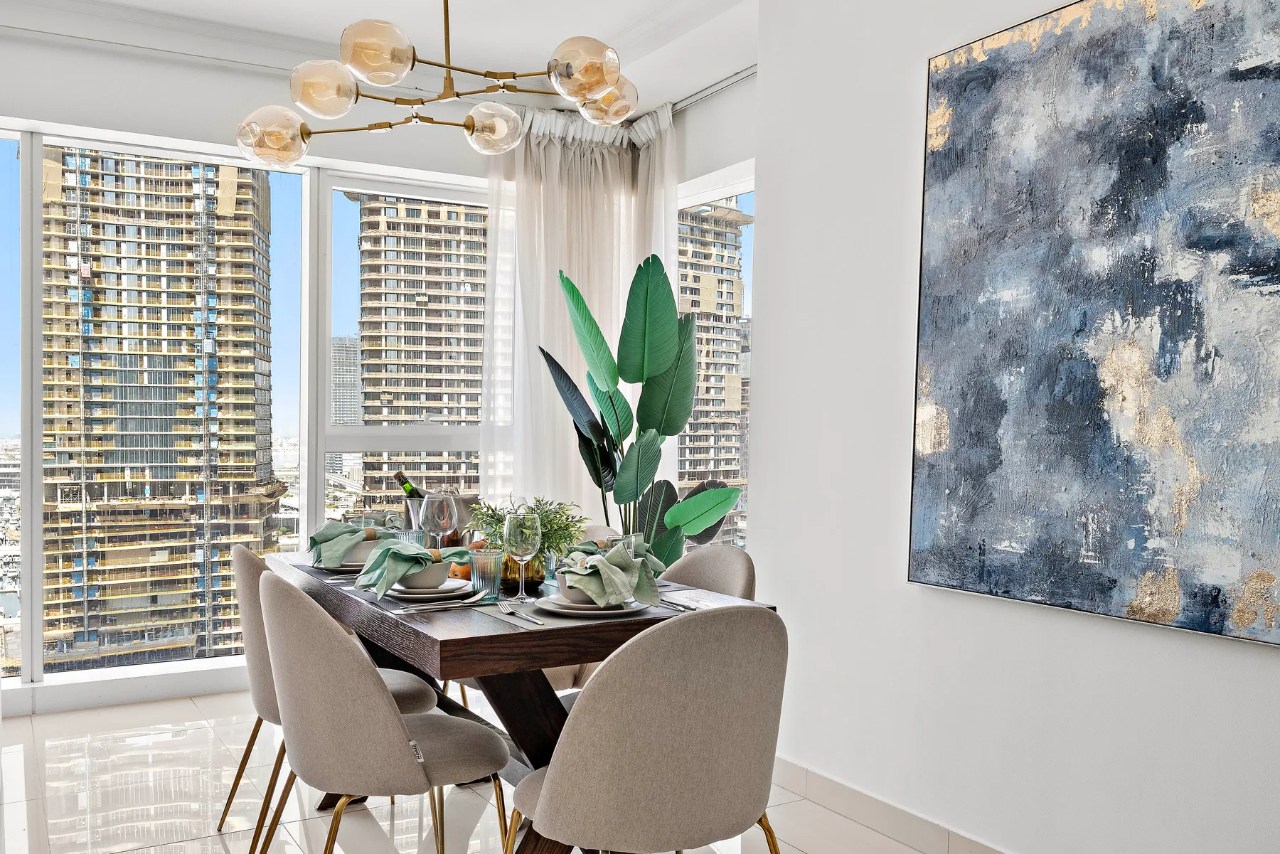 A dining area with a set table beside large windows.