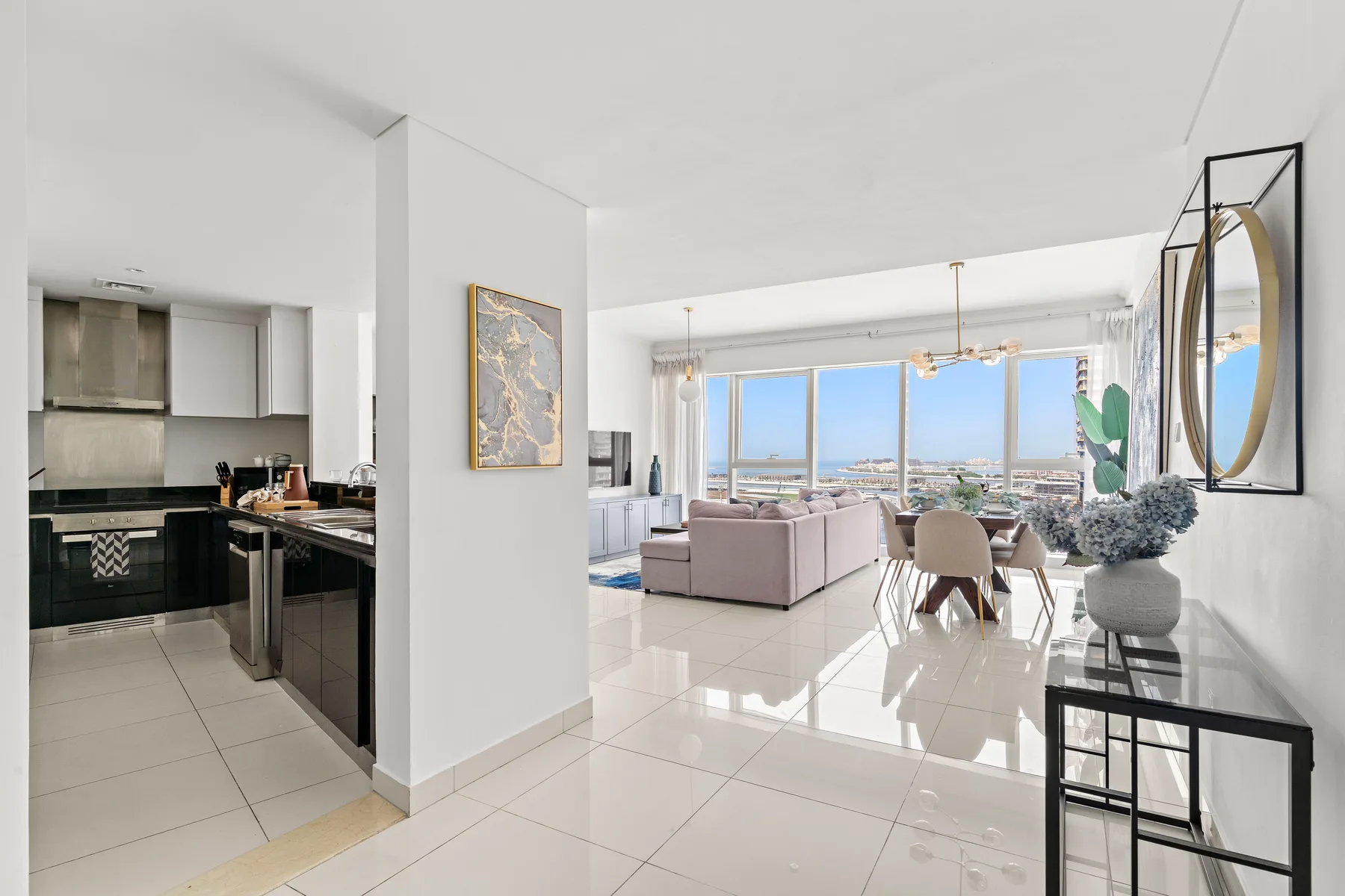 An open-plan living and dining area with a kitchen and large windows.
