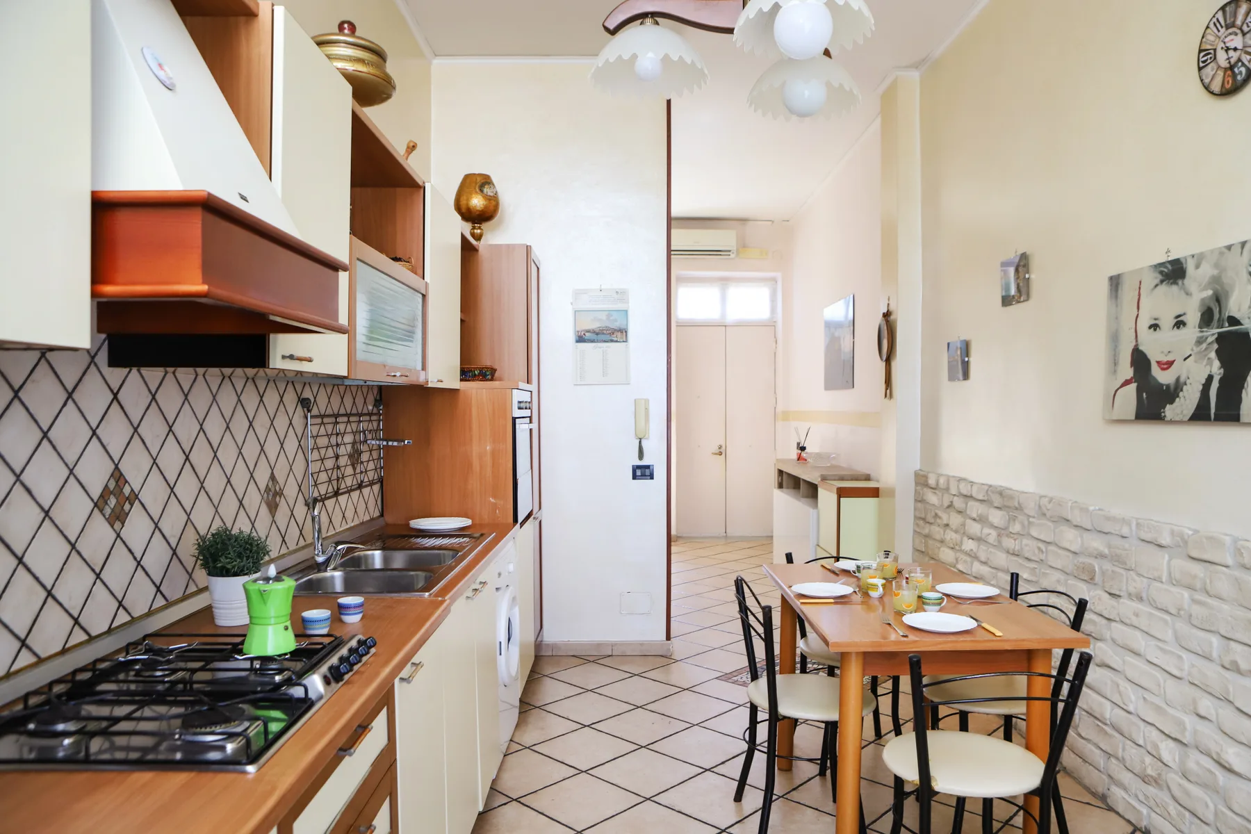 A narrow kitchen and dining area with a table set beside the counter.