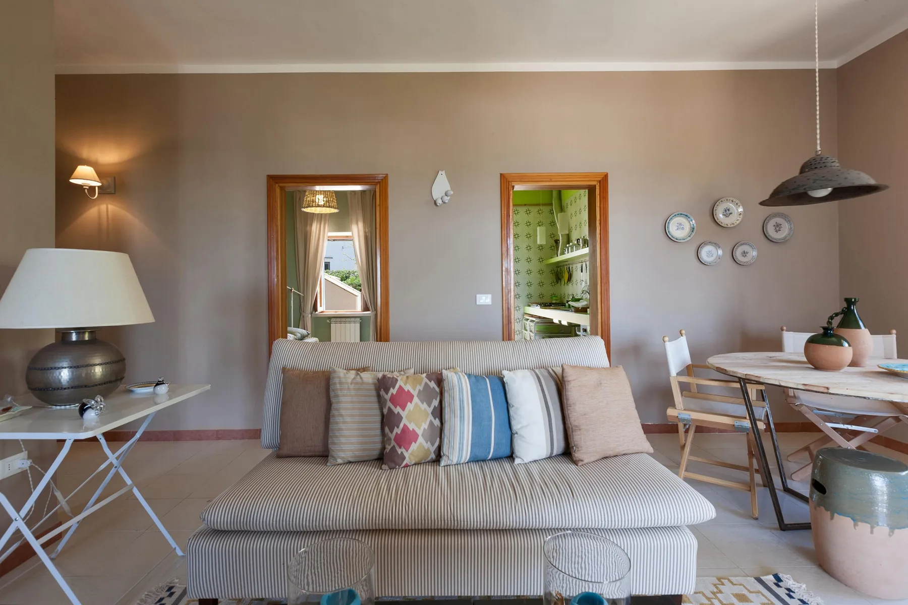 A living and dining area with a sofa, dining table, and wall decorations.