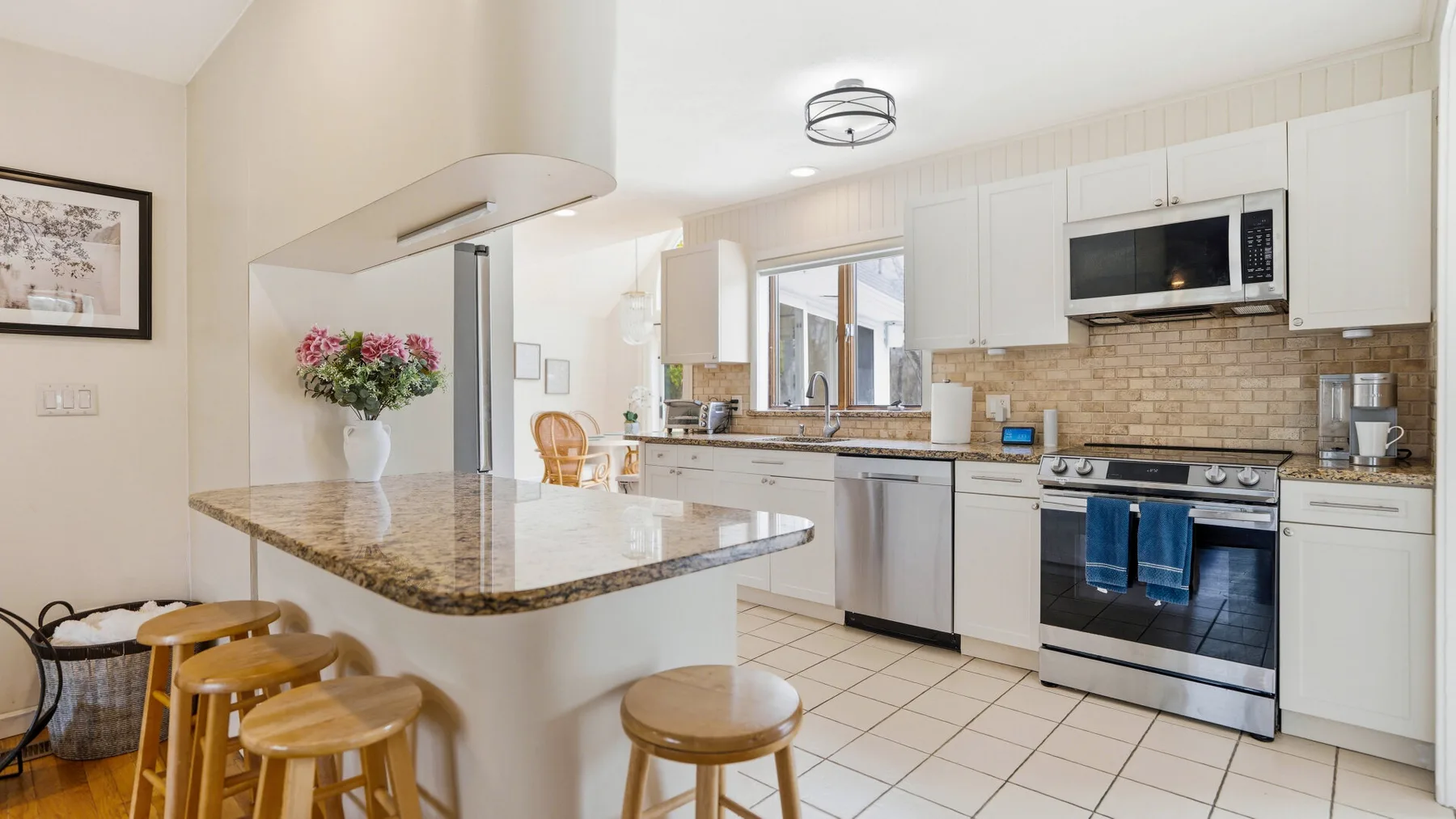 A bright kitchen with a wide island and stainless steel appliances.