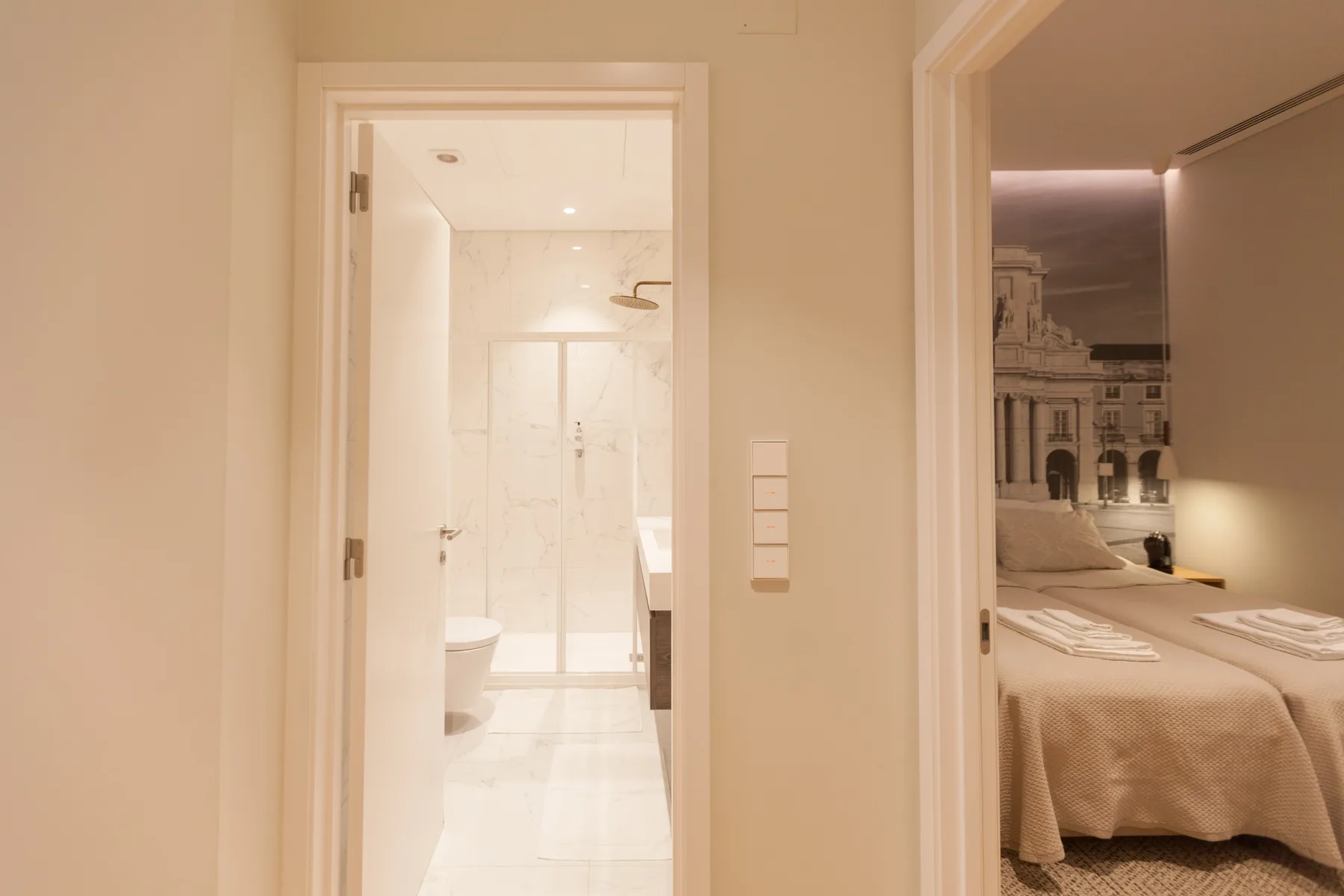 Dormitorio con una cama junto a una puerta abierta al baño.
