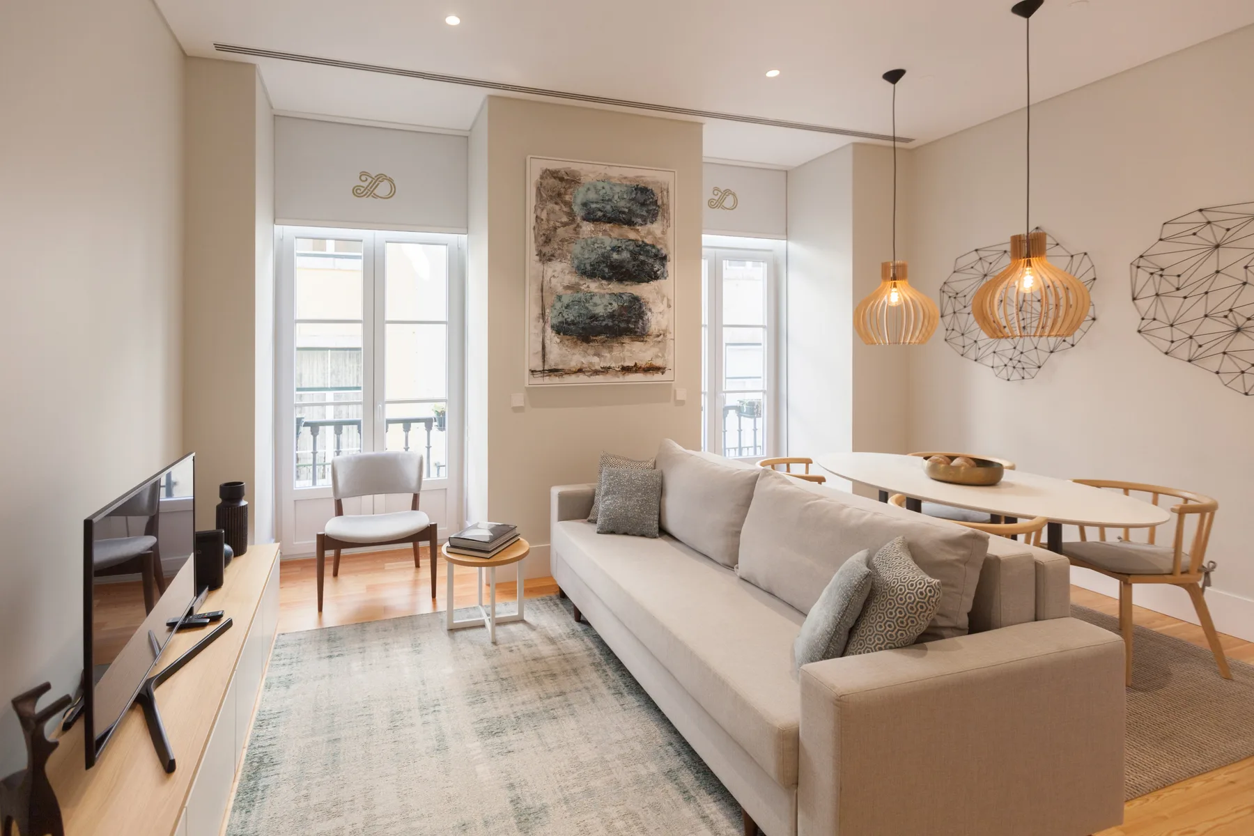 Una sala de estar luminosa con sofá, televisor y zona de comedor.