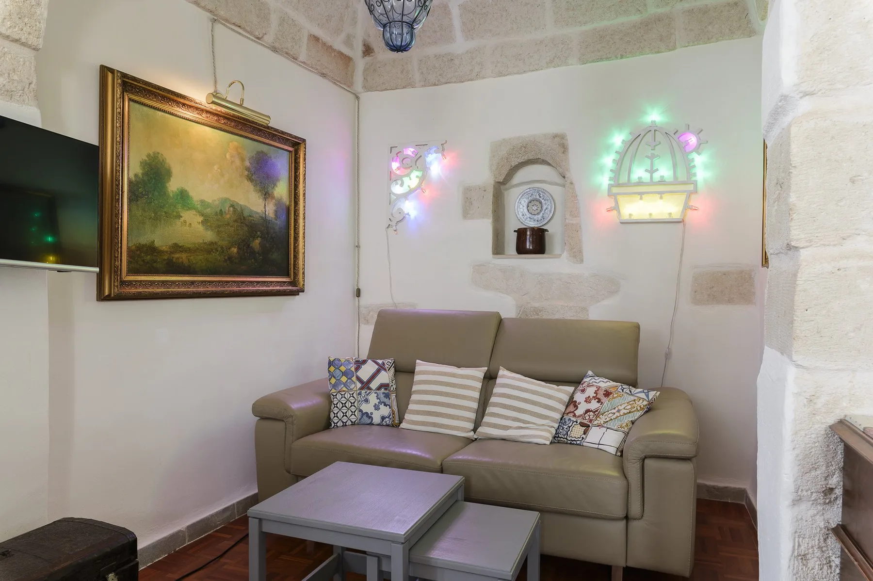 Una zona de estar con sofá, cojines y una mesa de centro.