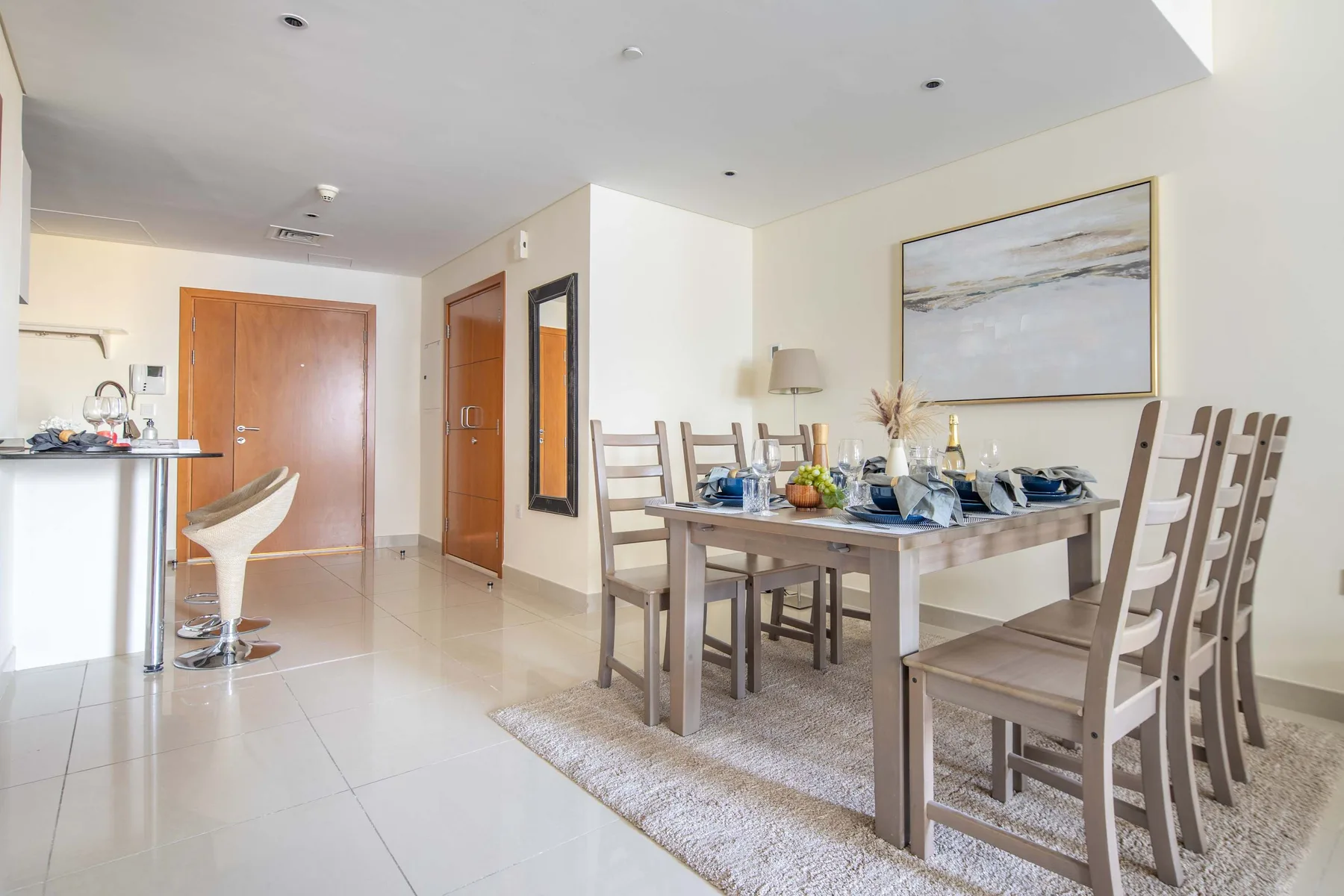 A bright dining area with a set table and an adjoining kitchen counter.