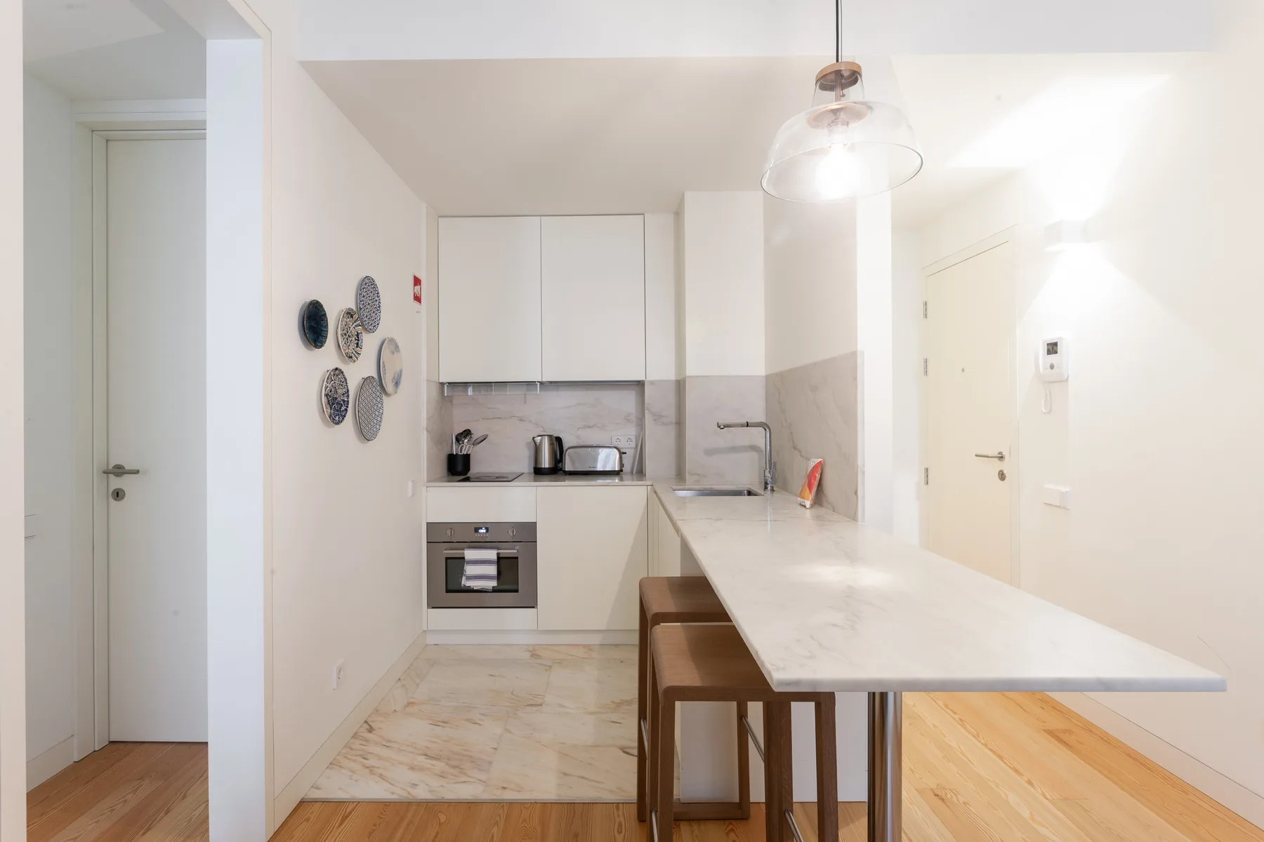 Una cocina luminosa con una barra larga y taburetes.